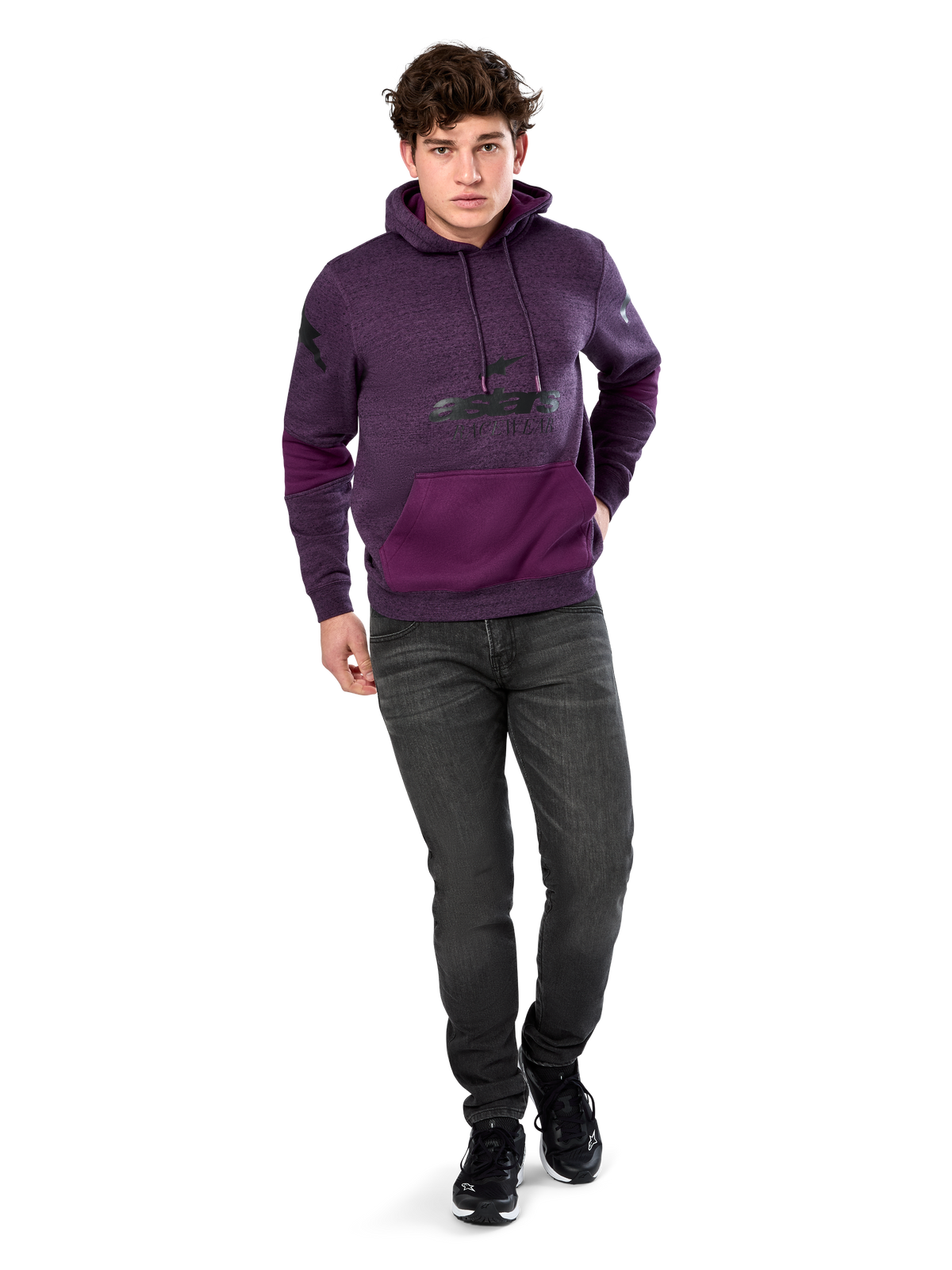Alpinestars Perpetuate Hoodie, casual streetwear, purple heather fleece with dark purple fabric blocking on the kangaroo pocket and sleeves, black chest logo, drawstring hood, worn by model with dark grey jeans and black sneakers