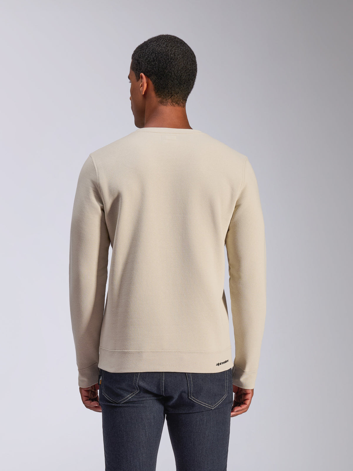 Alpinestars Positive Crew, Off White crewneck sweatshirt, back view, casual motorsport streetwear, ribbed hem and cuffs, featuring a small Alpinestars logo on the back hem