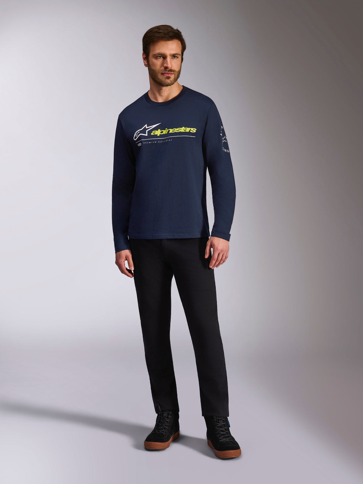 Alpinestars Mandatory CSF Tee, Long Sleeve T-Shirt, Navy Blue, White Astars Logo with Neon Yellow Word Logo, worn by a model with black pants and black sneakers, casual motorsport streetwear