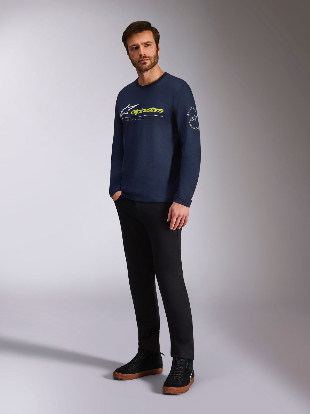 Alpinestars Mandatory CSF Tee, Long Sleeve T-Shirt, Navy, featuring front white Astars logo and yellow Alpinestars branding, Astars circle logo on sleeve, worn by a model with black pants and black sneakers for a casual lifestyle look
