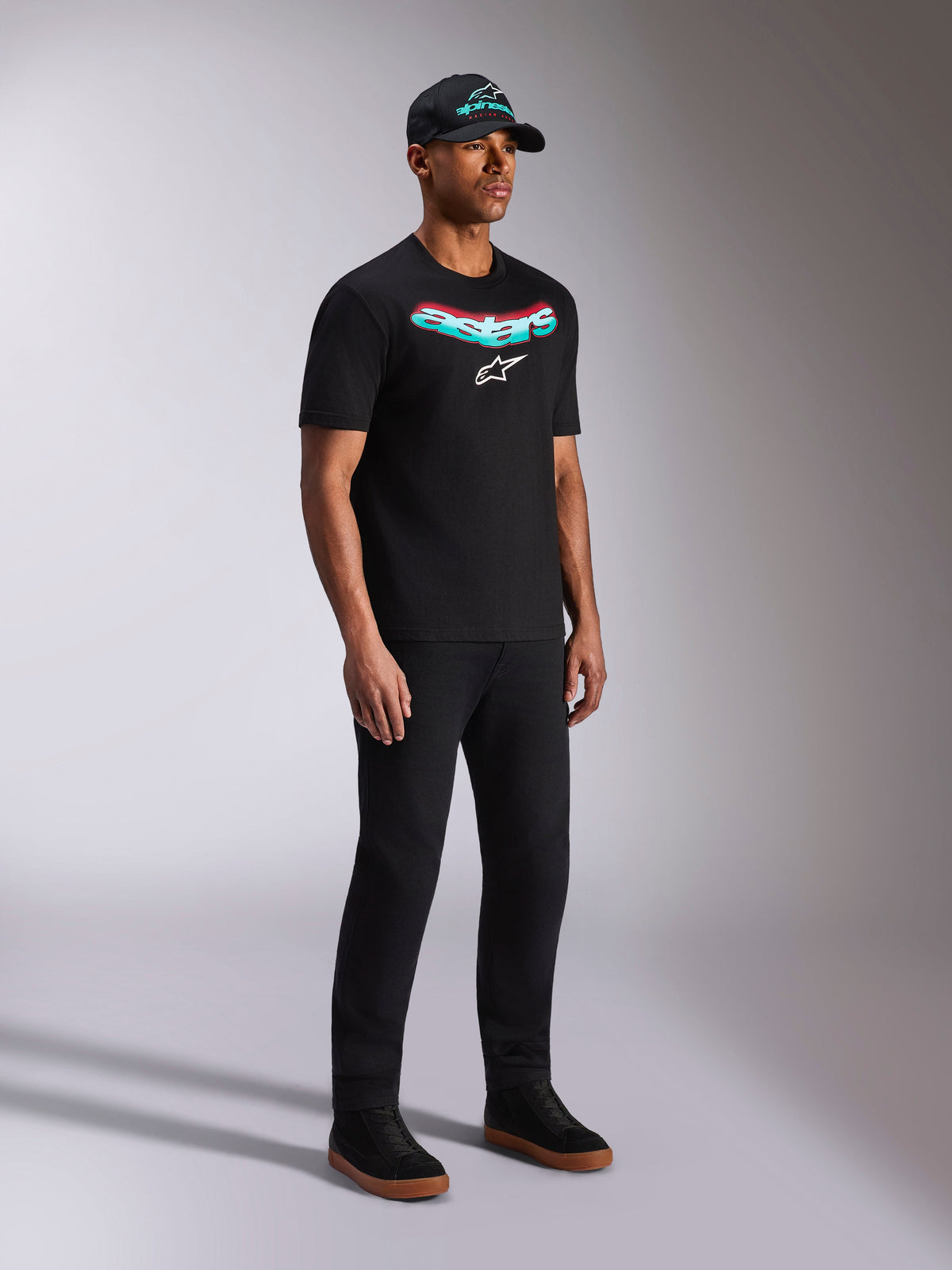 Alpinestars Ellipsoid CSF Tee, Black Short Sleeve T-Shirt, Teal and Red Gradient Astars Graphic with White Logo, Male model wearing casual streetwear with black cap and pants