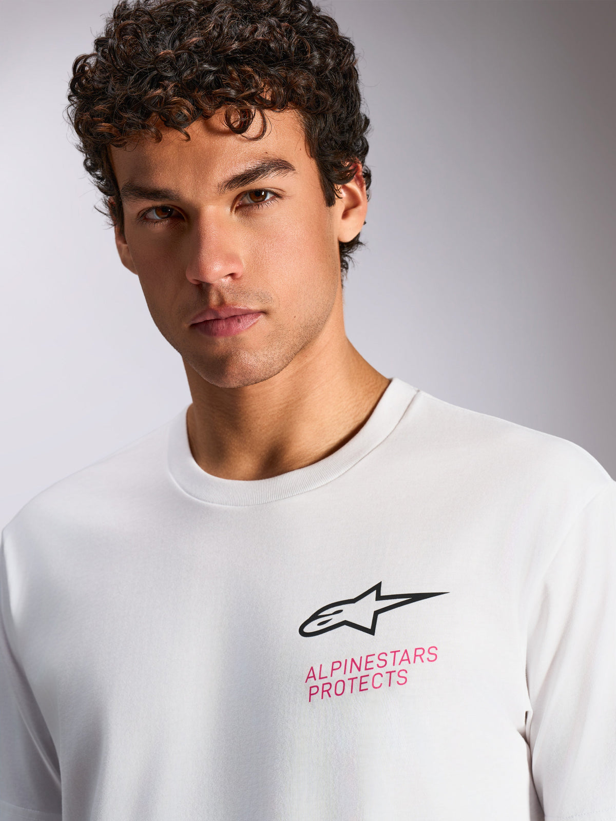 Alpinestars Pop Helmet CSF Tee, Short Sleeve T-Shirt, White, black Astars logo and pink 'ALPINESTARS PROTECTS' text on the chest, casual motorsport streetwear