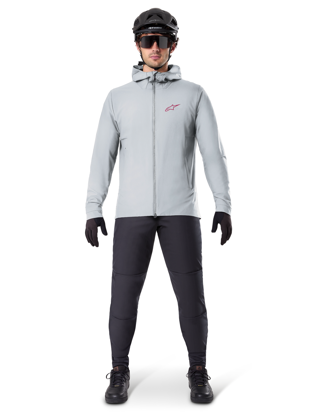 Alpinestars A-Dura Thermal Jacket, Titanium gray, cycling jacket worn with black mountain biking pants, gloves, and helmet, featuring a small red star logo on the chest and a full front zipper, lightweight insulated gear for off-road riding.
