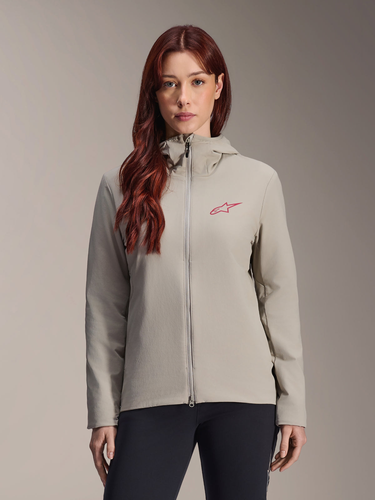 Alpinestars Stella A-Dura Thermal Jacket for women, Titanium gray, hooded zip-up design with red star logo on the chest, paired with black pants, lifestyle studio portrait