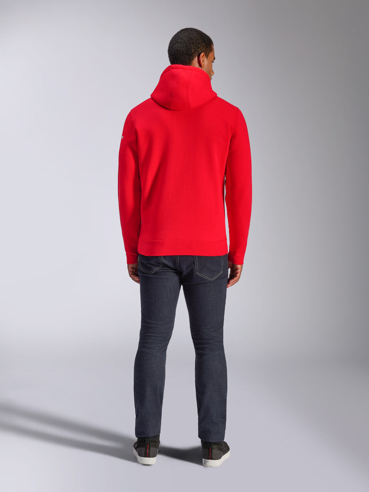 Alpinestars Frontal Hoodie, Red Pullover Fleece Hoodie, back view, casual streetwear style, worn with dark denim jeans and sneakers, features a hood and ribbed hem