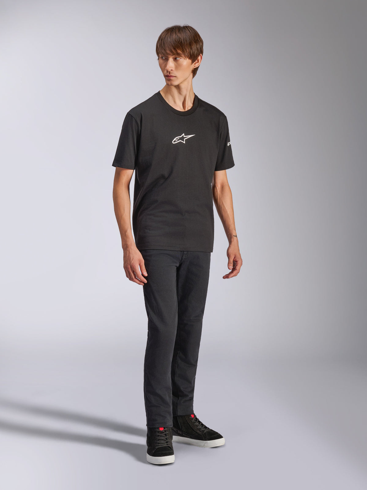 Alpinestars Frontal CSF Tee, Short Sleeve T-Shirt, Black, White Astars Logo on Chest, worn by a model with dark jeans and black sneakers, Casual Performance Streetwear
