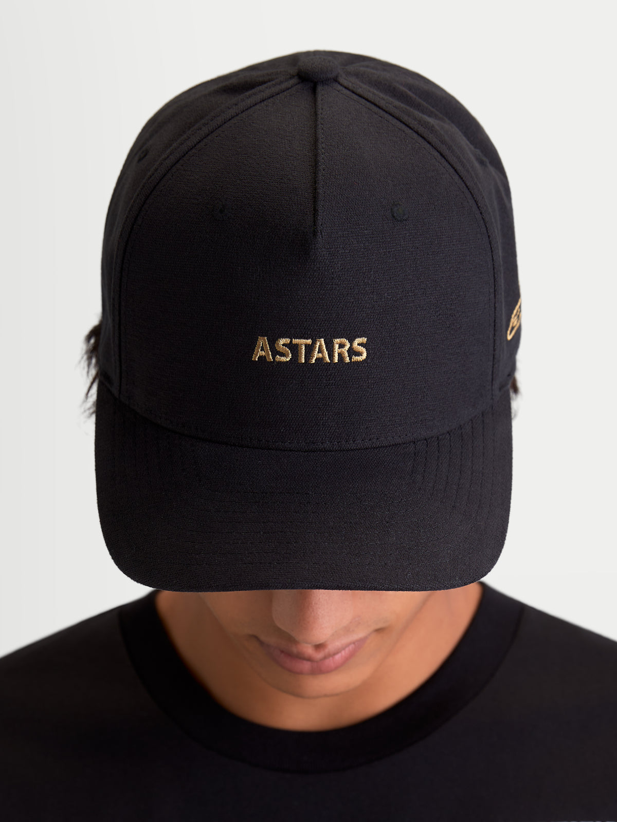 Alpinestars County Canvas Hat, Black Sportswear Cap with Gold ASTARS Logo Embroidery, Curved Bill and Structured Crown, Unisex Everyday Motorsport-Inspired Hat, Oxford Peached Fabric, Front View on Model