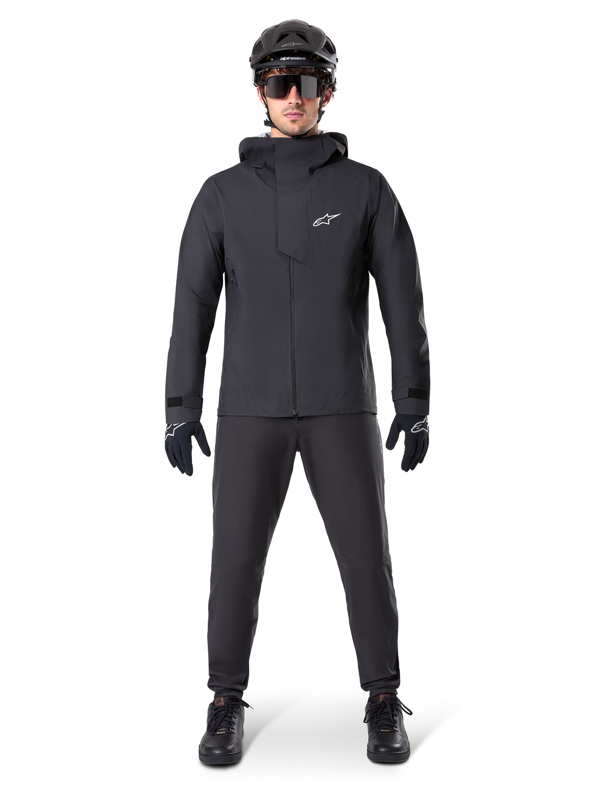Alpinestars A-Dura Waterproof Pants, black MTB pants, worn as part of a complete all-black mountain biking gear set including a technical waterproof jacket, black helmet, sunglasses, and gloves, designed for wet-weather off-road riding.