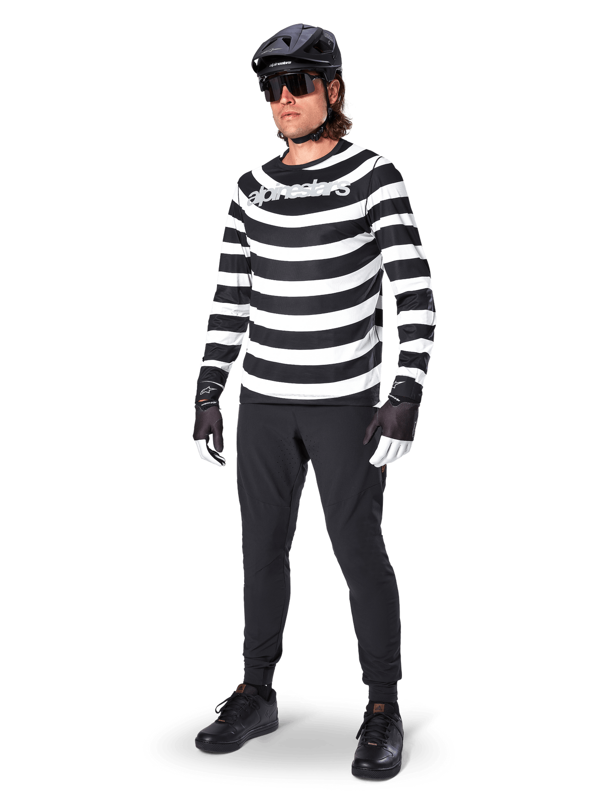 Alpinestars A-Aria Elite Pants, Black MTB Pants, worn by a rider with a black and white striped long-sleeve jersey, black helmet, sunglasses, and black and white gloves, performance gear for off-road cycling