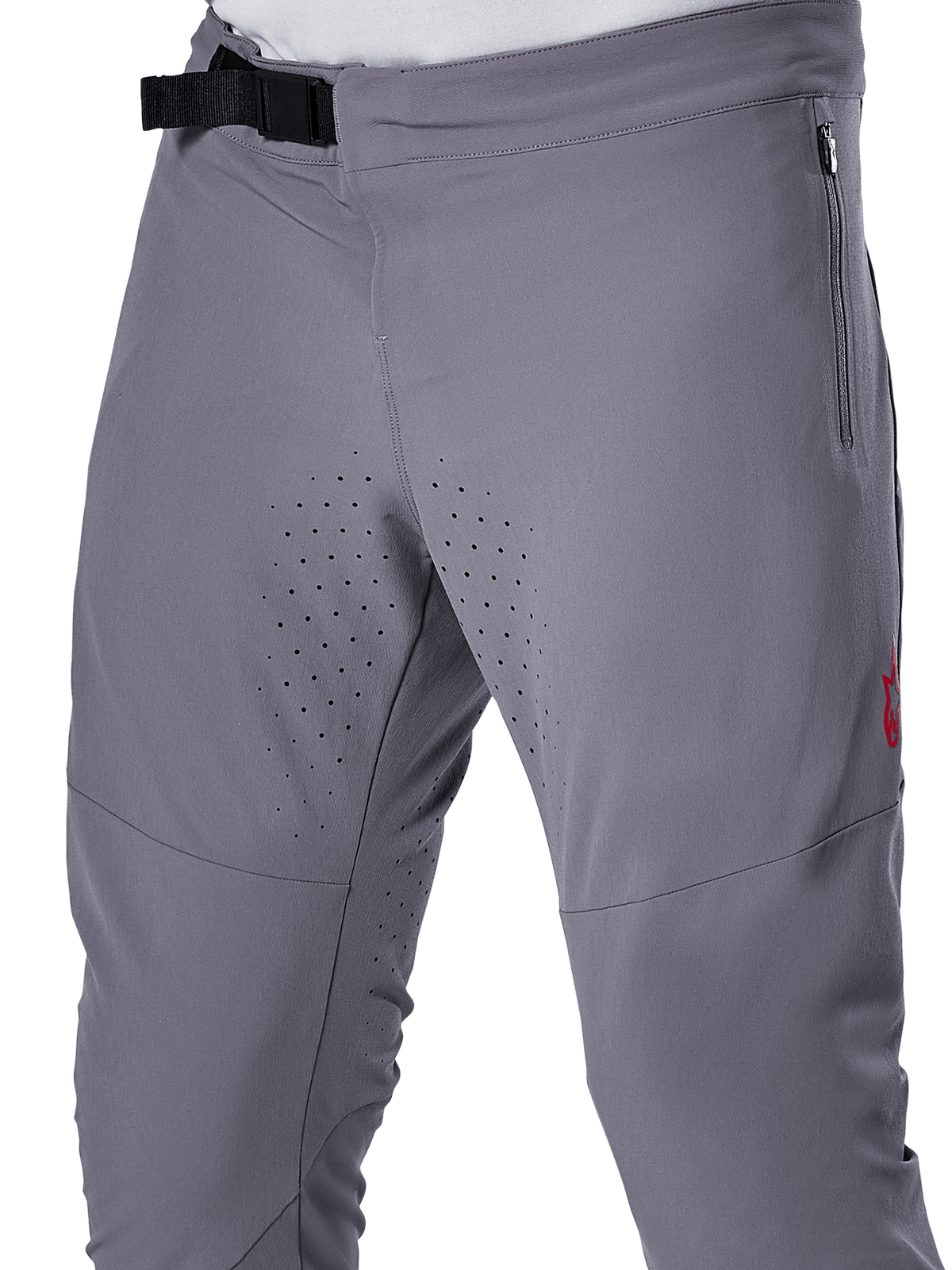 Alpinestars A-Aria Elite Pants, MTB Cycling Pants, Dark Gray, close-up view featuring the magnetic buckle closure, zippered side pocket, and laser-cut ventilation perforations on the inner thighs for trail riding performance.