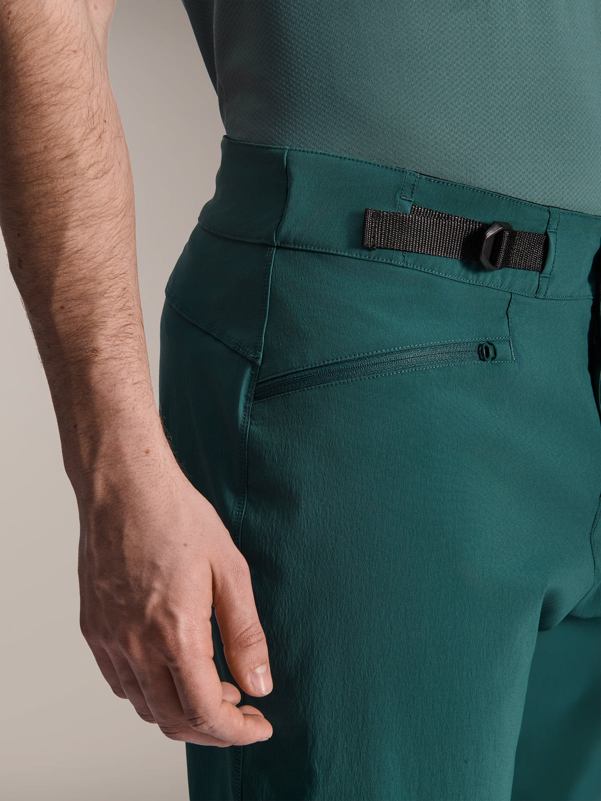 Alpinestars A-Dura Shorts, Dark Pine Green, close-up view of the adjustable side cinch waist strap and zippered pocket, durable performance gear for mountain biking.