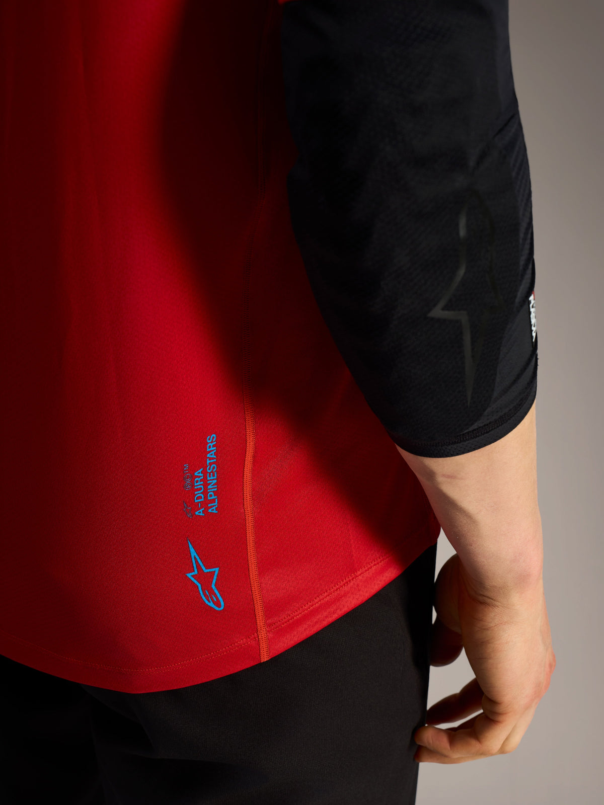 Red A-Dura Ride Short Sleeve Jersey detail with blue Alpinestars logos and technical performance fabric for MTB.