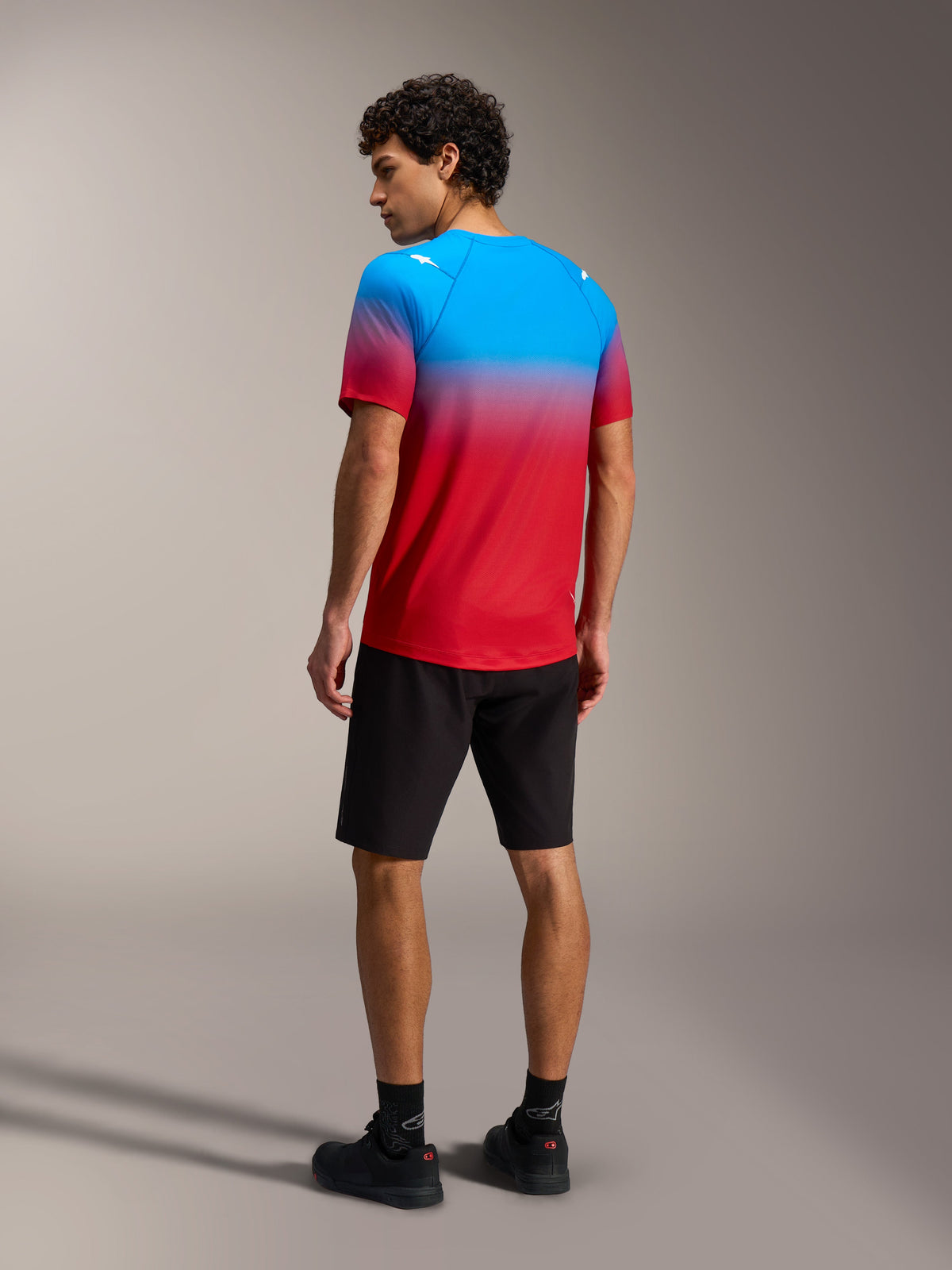 A-Dura ASTARS 2.0 Short Sleeve Jersey, Bright Red Blue gradient, back view on model, performance mountain bike gear.
