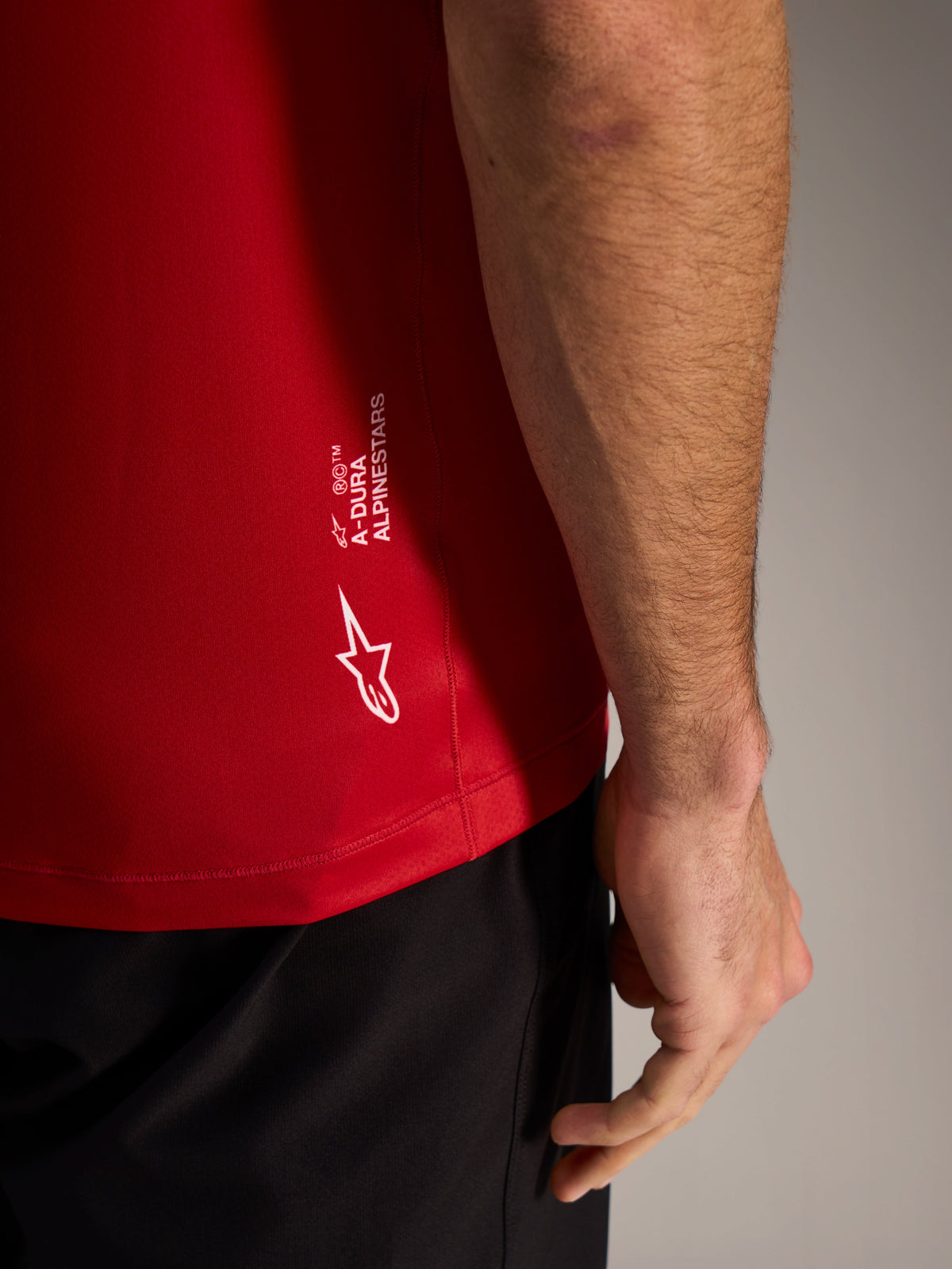 Red A-Dura ASTARS Jersey 2.0 close-up featuring white branding and breathable jacquard fabric for mountain biking.