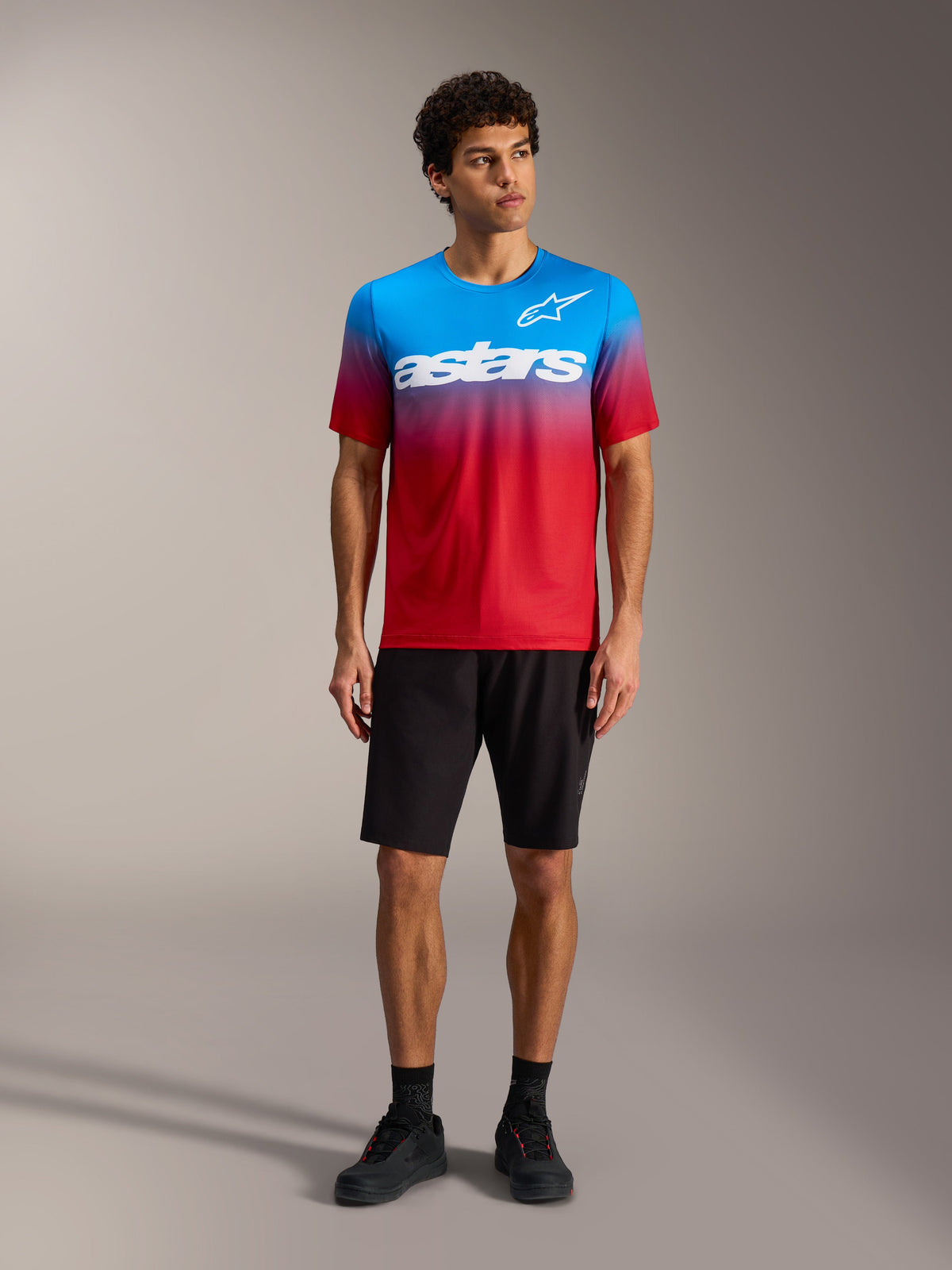 A-Dura ASTARS Jersey 2.0 in Bright Red Blue gradient with white chest logo, paired with black MTB shorts and shoes.