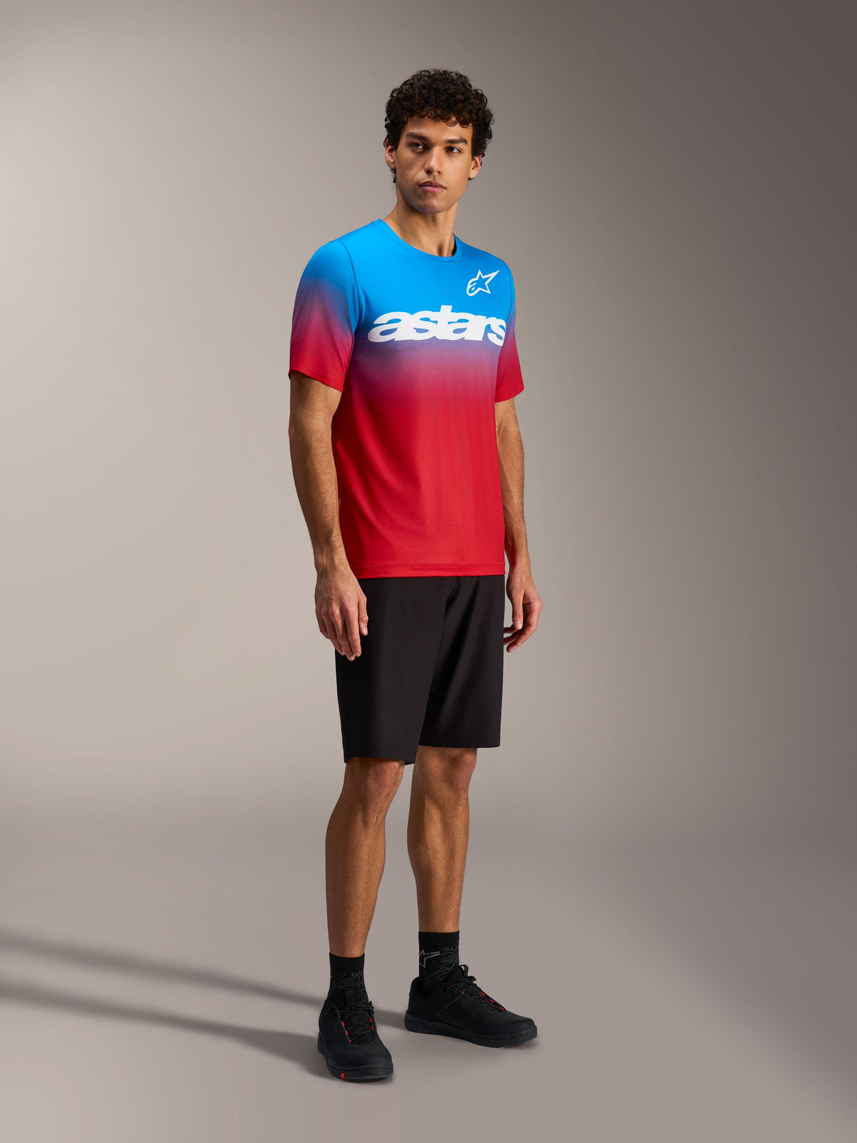 Alpinestars A-Dura ASTARS Jersey 2.0 in bright red and blue gradient, short sleeve MTB top with white chest wordmark.