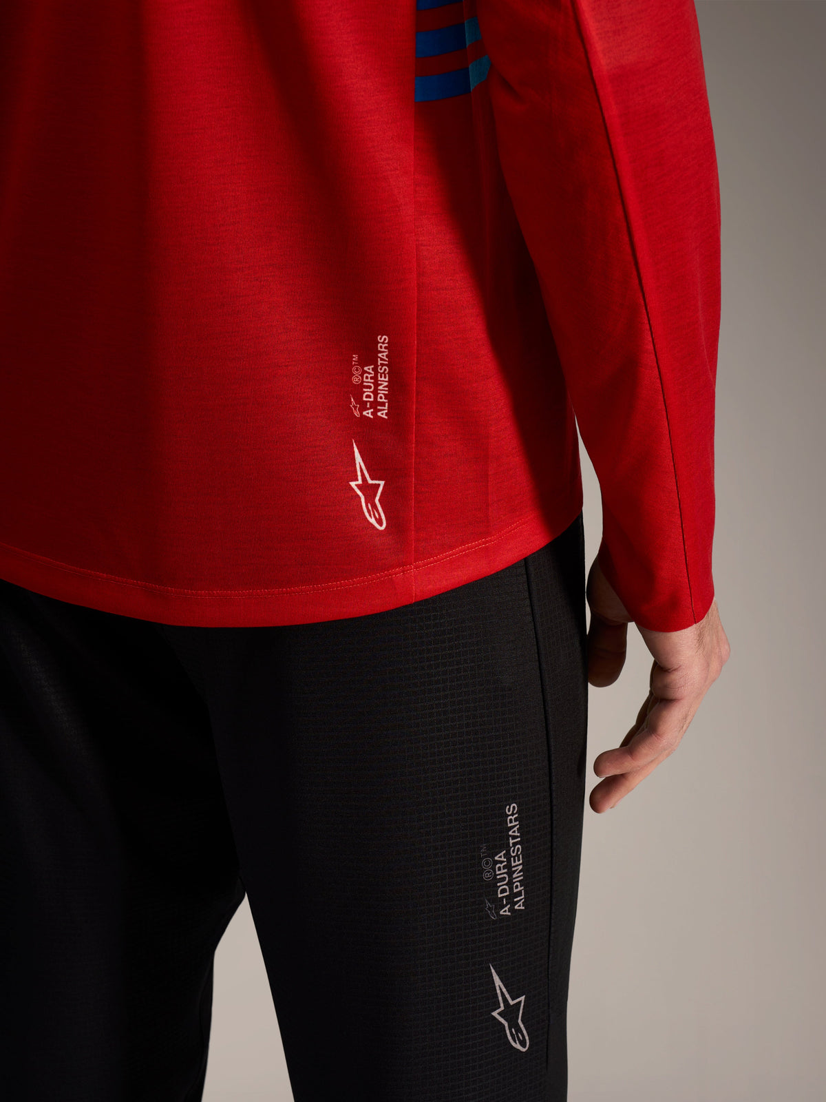 Red A-Dura Elite Long Sleeve Jersey 2.0 and black MTB pants featuring branded Alpinestars logos and performance fabric.