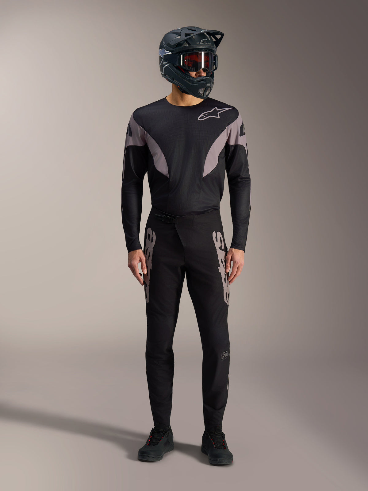 Black A-Supra Elite MTB kit featuring a long-sleeve jersey and racing pants with grey logos and a full-face helmet.