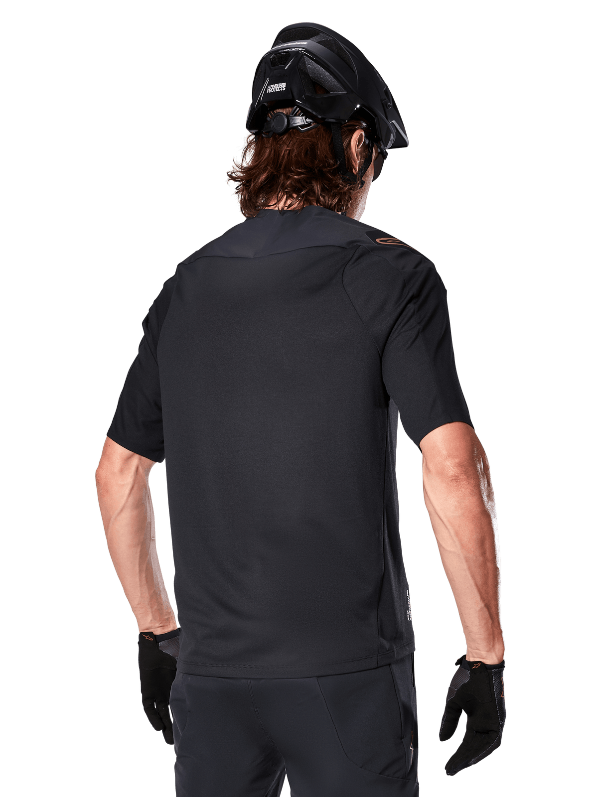 Alpinestars A-Aria Polartec Switch Short Sleeve Jersey, Black, rear view on a rider wearing a black mountain bike helmet, matching black shorts and gloves, performance gear for mountain biking