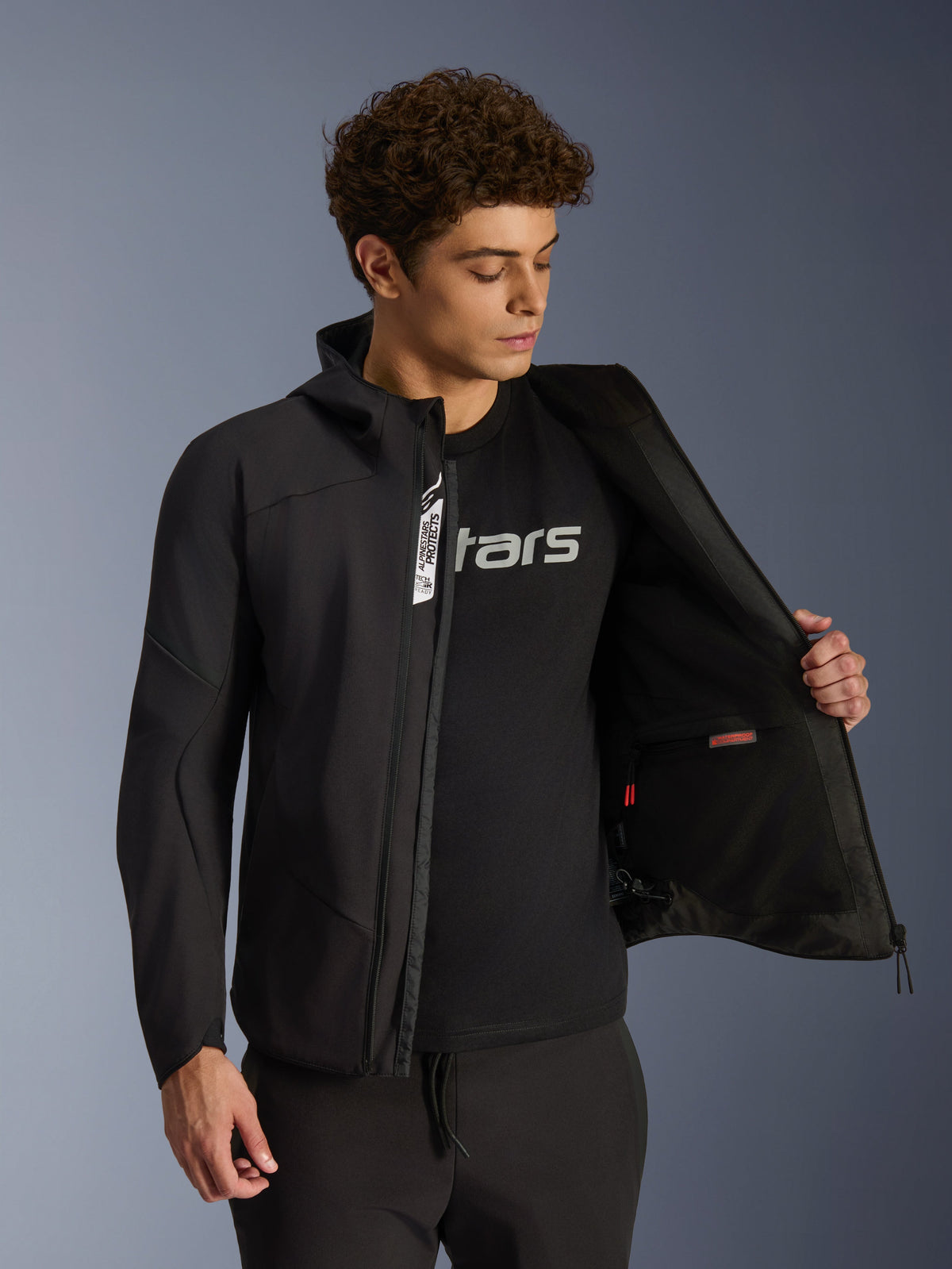 Alpinestars Aeroshell Waterproof Jacket, black softshell urban motorcycle jacket for men, unzipped showing interior pocket.