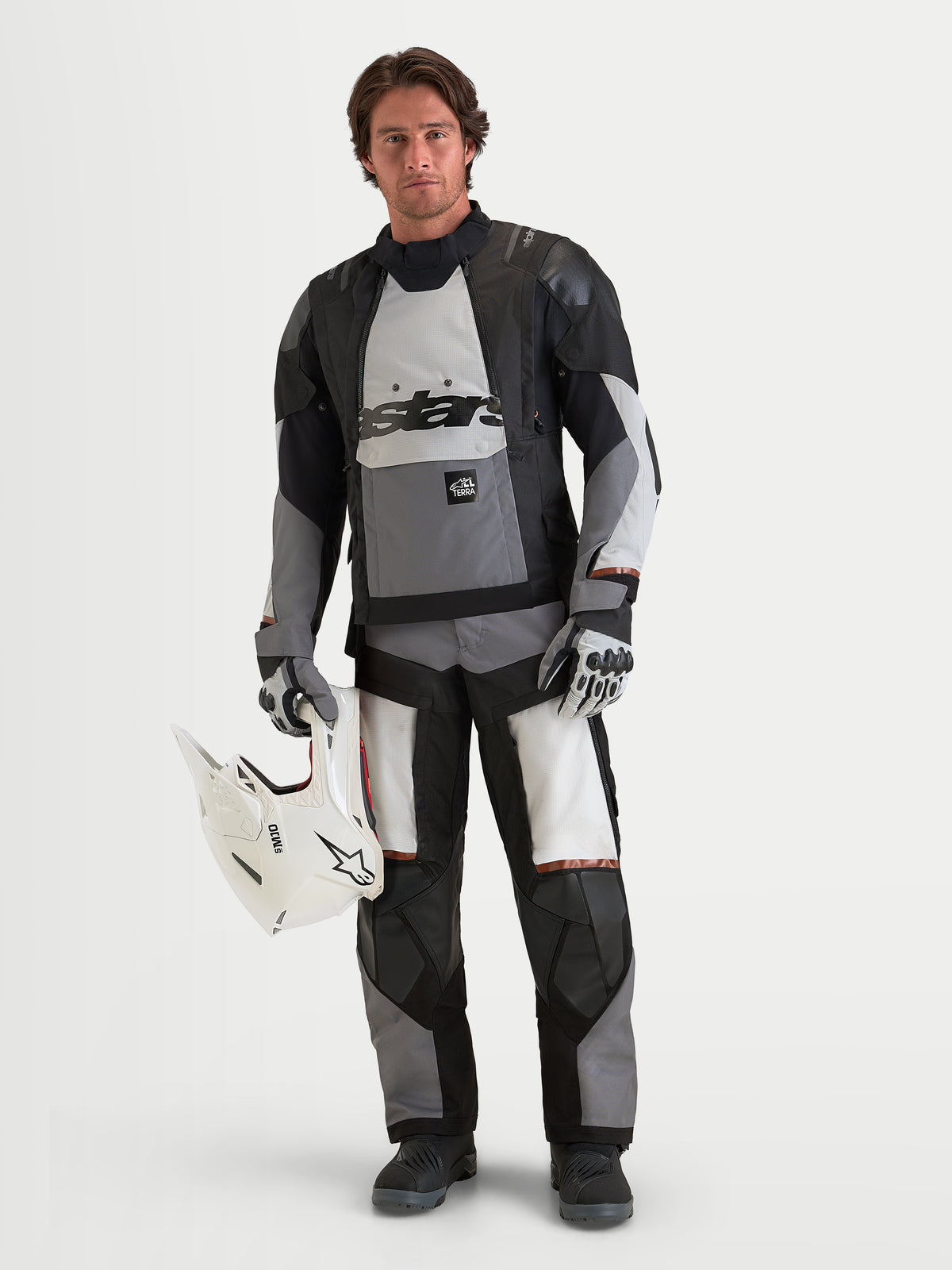 Alpinestars Harok V2 Drystar Jacket, Men's All-Terrain Adventure Motorcycle Jacket, Dark Gray, Ice Gray and Black, waterproof textile construction with CE-certified protection, worn by a male model holding a white helmet