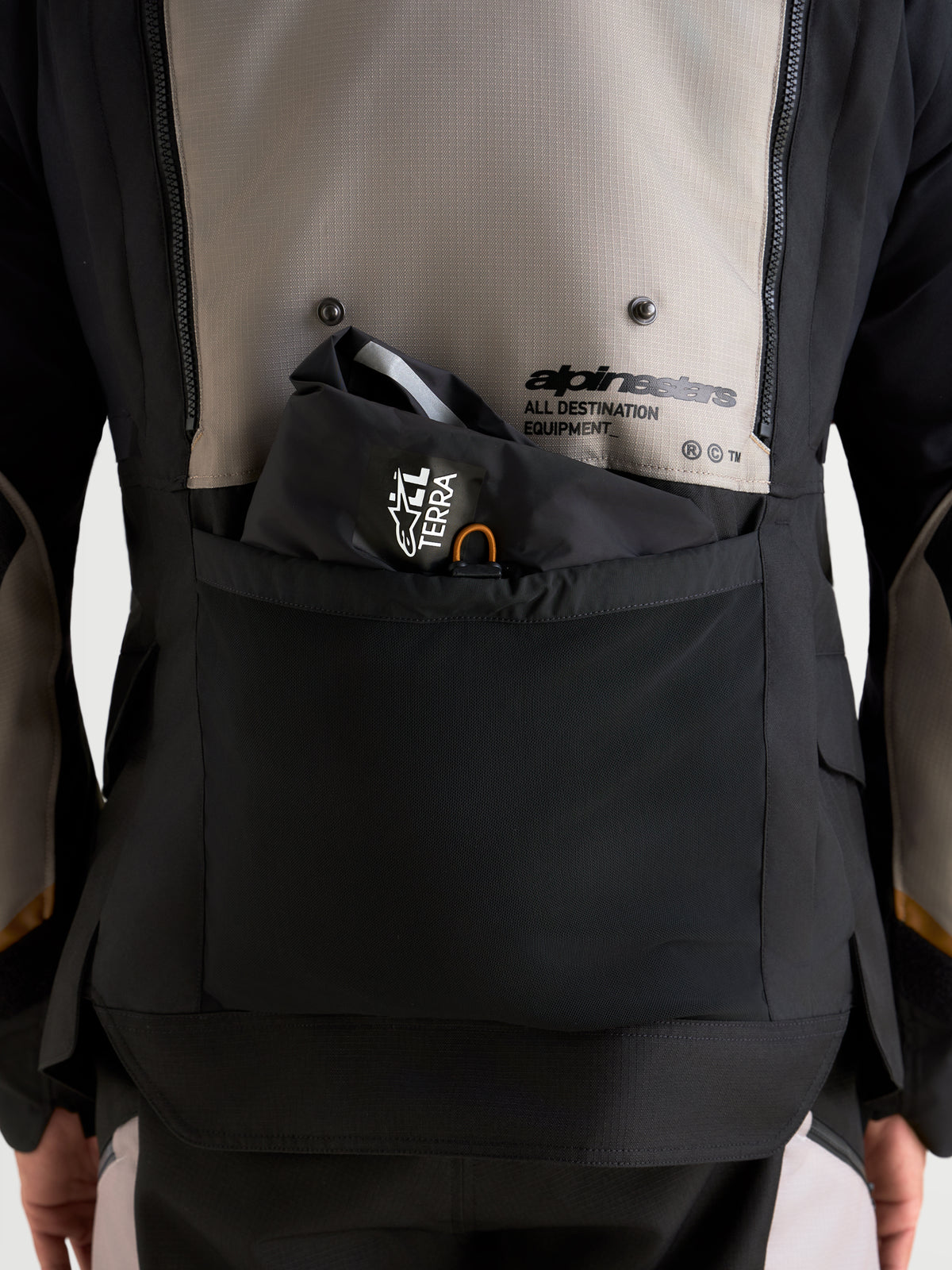 Alpinestars Harok V2 Drystar Jacket, close-up of back storage pocket and venting details, men's adventure motorcycle jacket, aluminum, walnut, and black, featuring Alpinestars All Destination Equipment branding