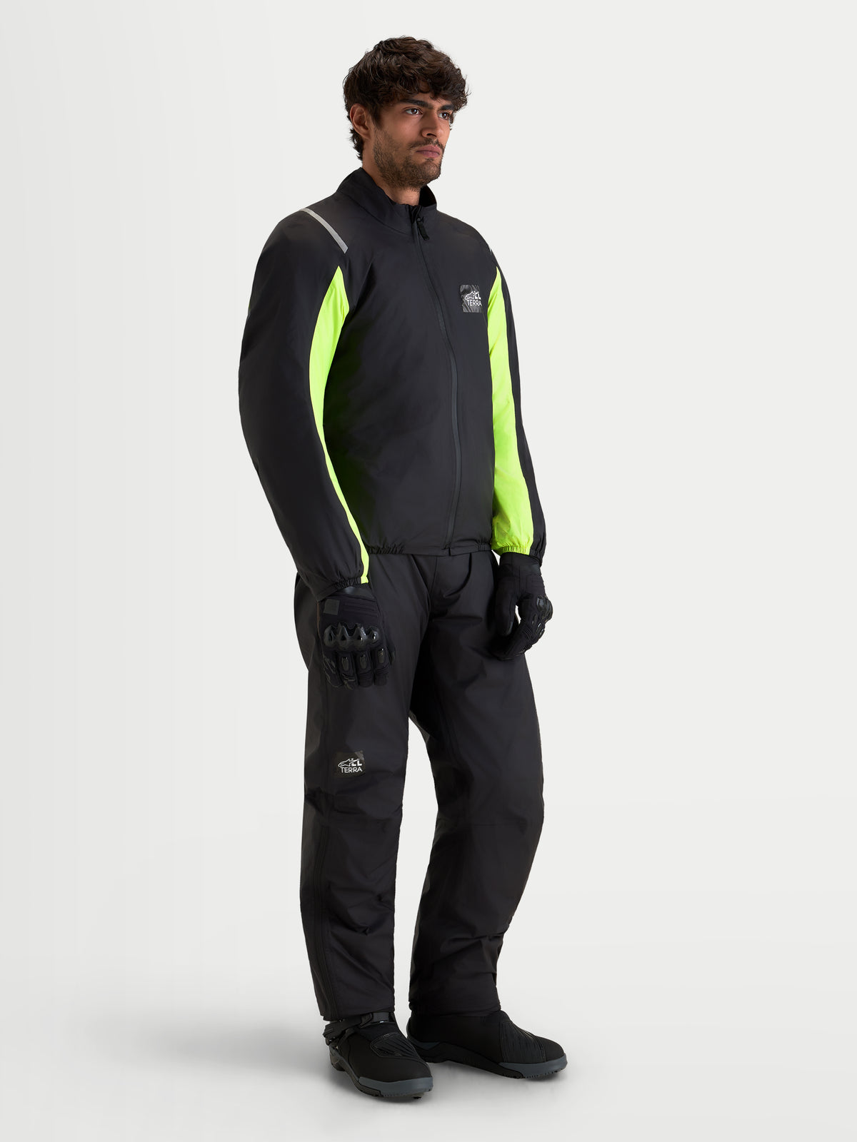 Alpinestars Harok V2 Drystar Gear Set, men's motorcycle riding gear featuring a waterproof jacket and matching pants in black with high-visibility yellow panels and black gloves, full-body studio view on a model