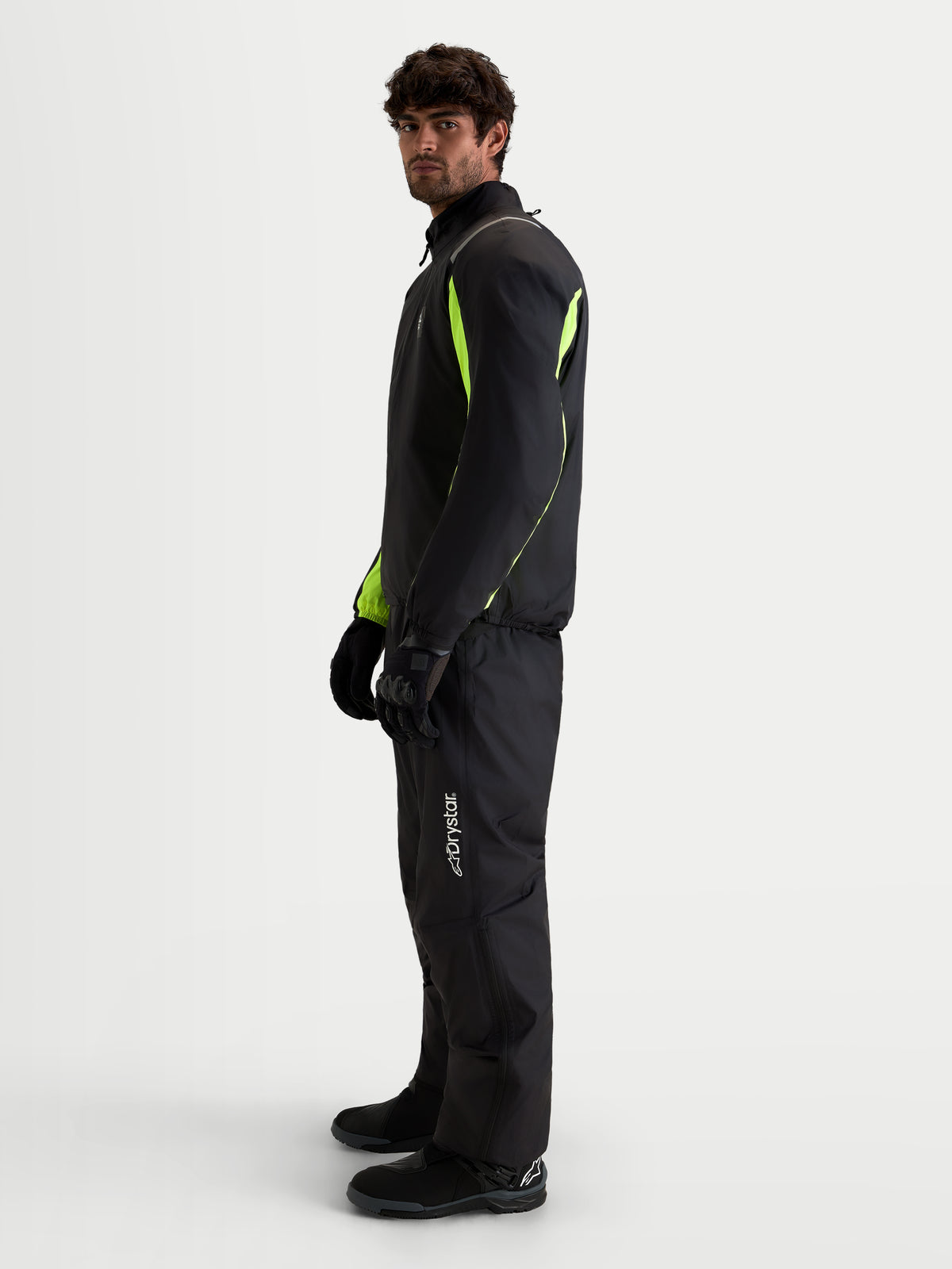 Alpinestars Harok V2 Drystar Gear Set, motorcycle waterproof textile jacket and pants, black and fluorescent yellow, side profile view on a model wearing matching gear and gloves