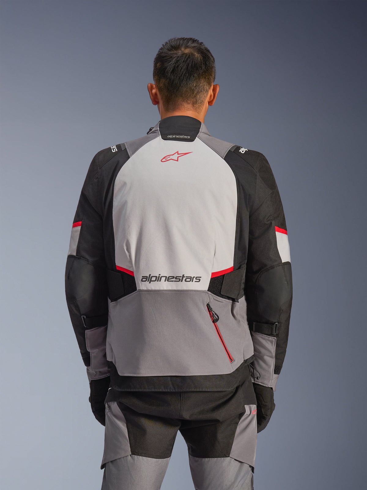 Alpinestars Andes V4 Drystar® Jacket, Back View, Dark Gray, Ice Gray, Black, and Bright Red, featuring a red Astar logo and Alpinestars wordmark on the back, reinforced panels, and a red zipper pocket, adventure motorcycle riding gear