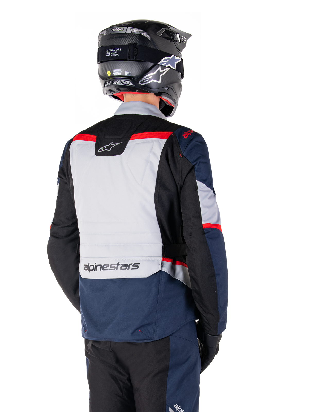 Alpinestars ST-1 Waterproof Jacket, Dark Blue Black and Bright Red, back view on a rider wearing a black adventure helmet, featuring light gray panels and Alpinestars branding, adventure touring motorcycle gear