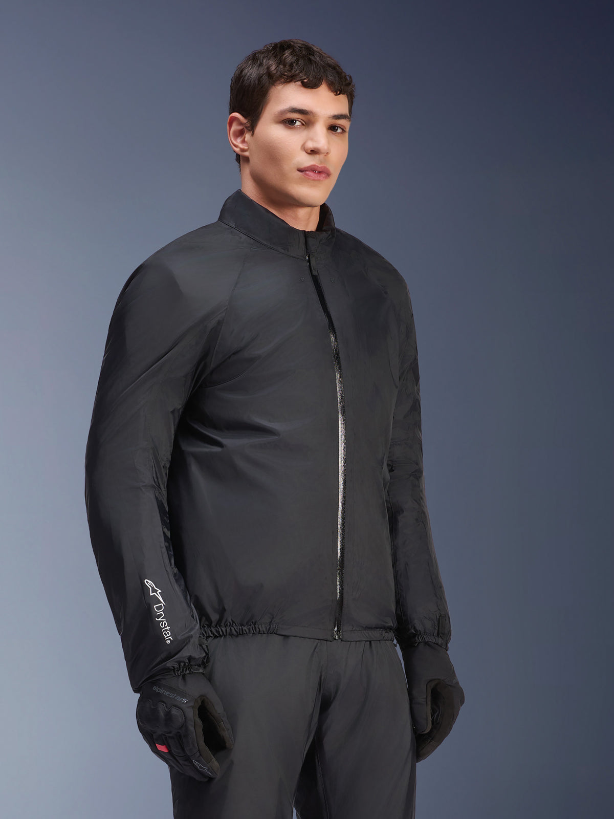 Alpinestars Andes Air Drystar® Jacket waterproof membrane, Black, worn by a male model with black gloves and pants, lightweight technical textile with 'Drystar' branding on the sleeve, studio shot