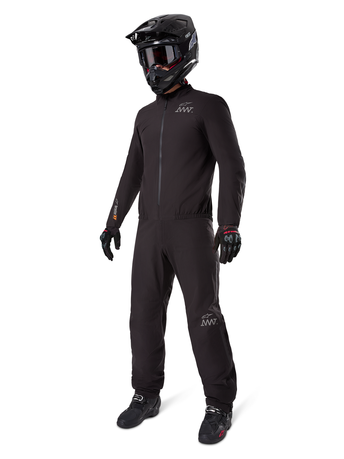 Alpinestars AMT-8 Stretch Drystar XF Liner, full black adventure touring suit, waterproof and windproof jacket and pants, paired with a black adventure helmet, goggles, gloves, and riding boots, featuring AMT logos and Drystar XF branding on sleeves and legs.
