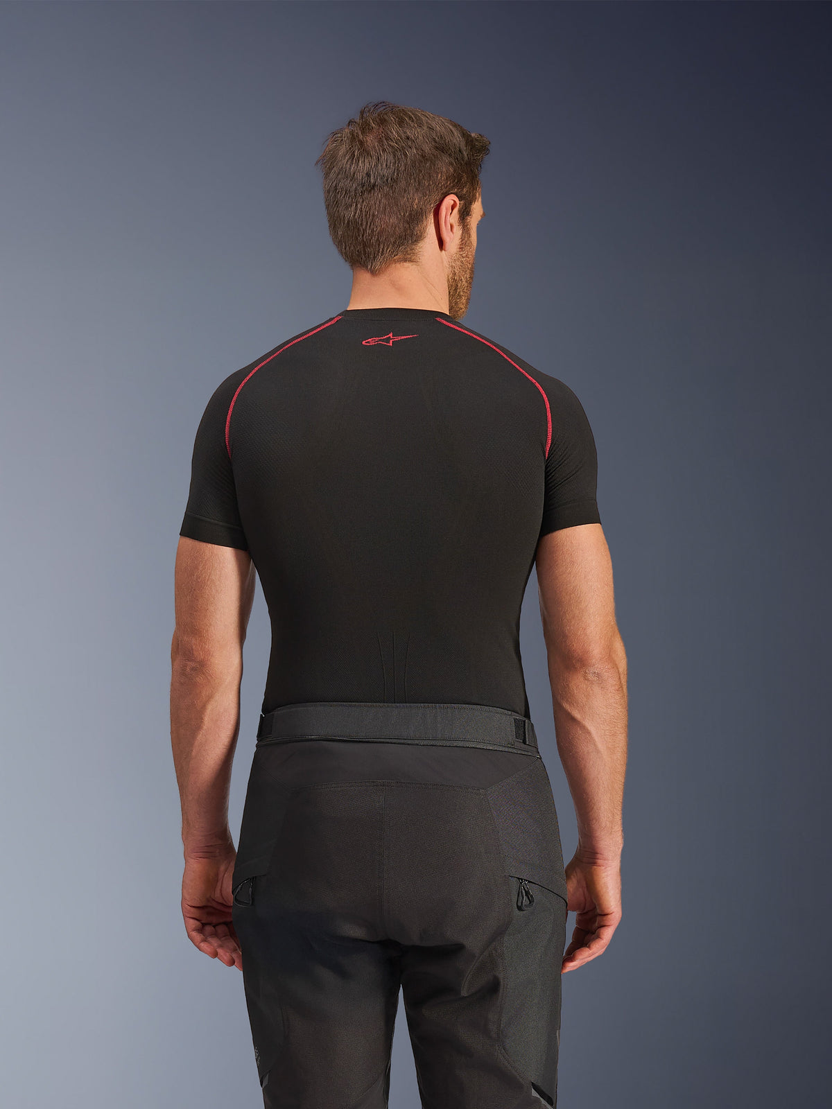 Alpinestars Cusco Drystar® Pants, Black Motorcycle Pants, back view of rider wearing adventure touring gear with a black short-sleeve compression top featuring red stitching, durable ripstop and 600D fabric construction.