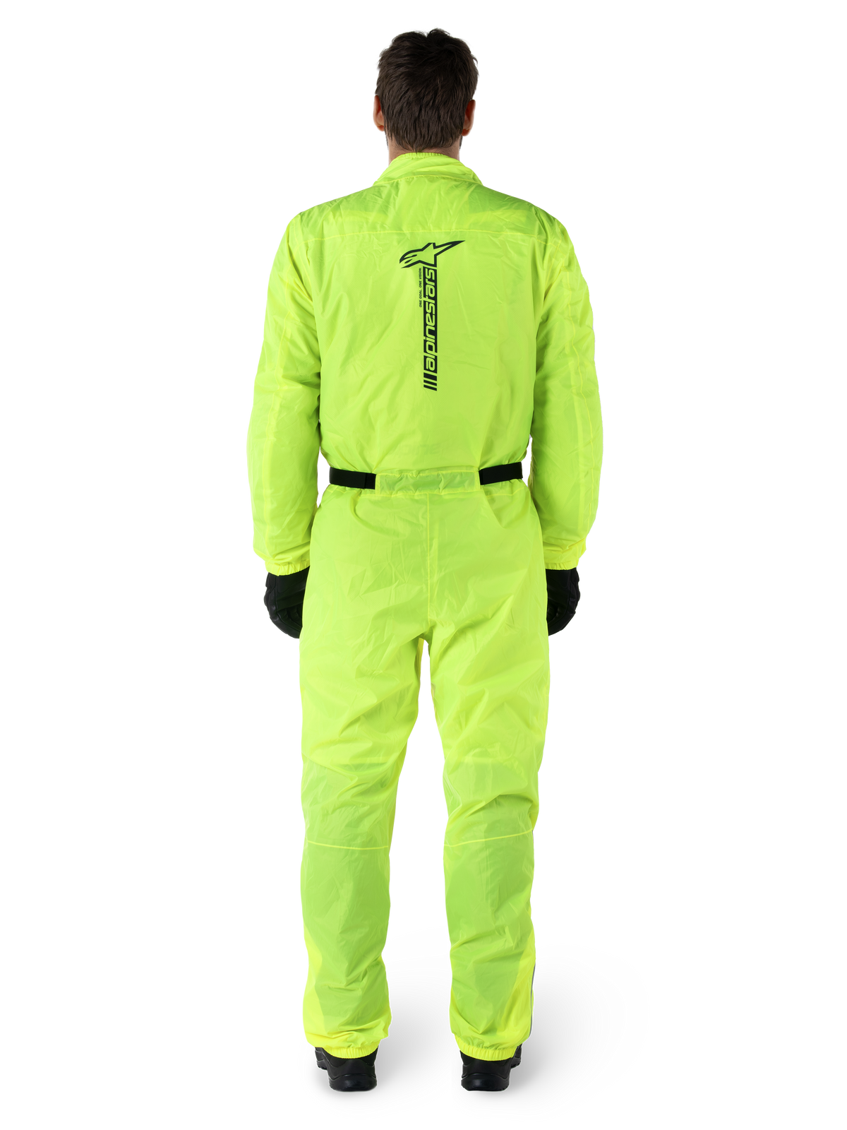 Alpinestars Hurricane Rain V2 Suit, One-piece Motorcycle Rain Suit, Yellow Fluo, back view featuring vertical black Alpinestars branding, elasticated waist and cuffs, worn with black gloves and boots, waterproof and wind-resistant riding gear