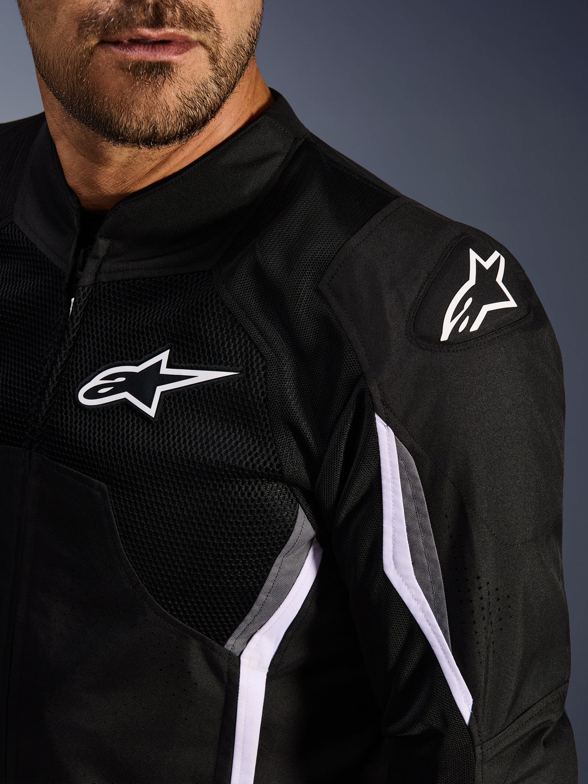 Alpinestars AST V3 Air Jacket, Textile Motorcycle Jacket, Black Dark Gray White, close-up featuring mesh panels, white Alpinestars logo on chest and shoulder, and DFS GP Lite Evo external shoulder sliders