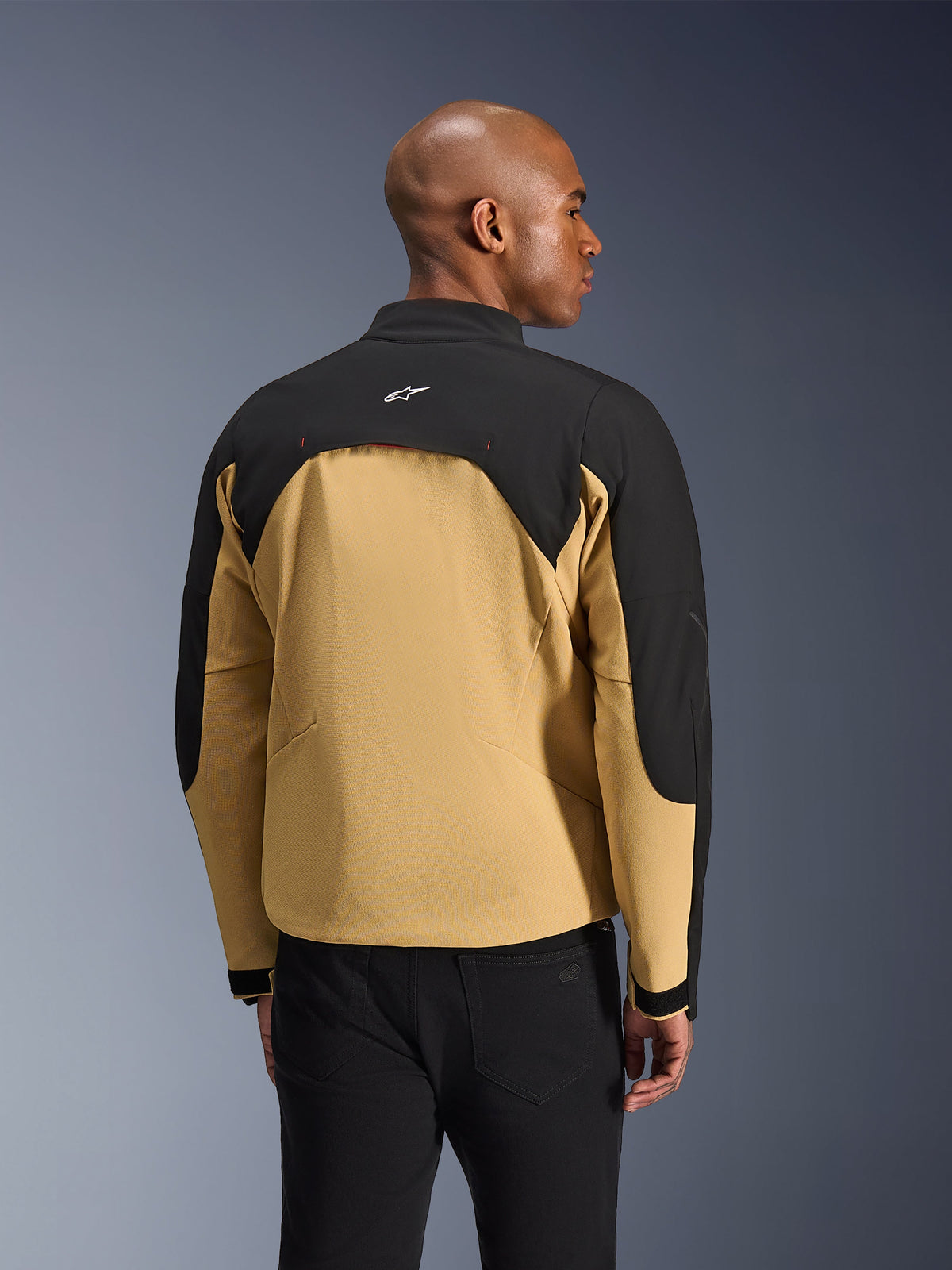 Alpinestars Provoke Jacket, Urban Motorcycle Jacket, Black and Camel, rear view showing two-toned construction, mesh-lined back ventilation panel, small white logo on upper back, worn with black pants
