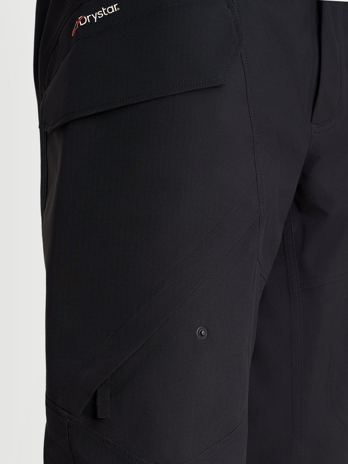 Alpinestars Juggernaut V2 Drystar Pants, urban motorcycle waterproof pants in black, close-up view highlighting the side cargo pocket and Drystar branding