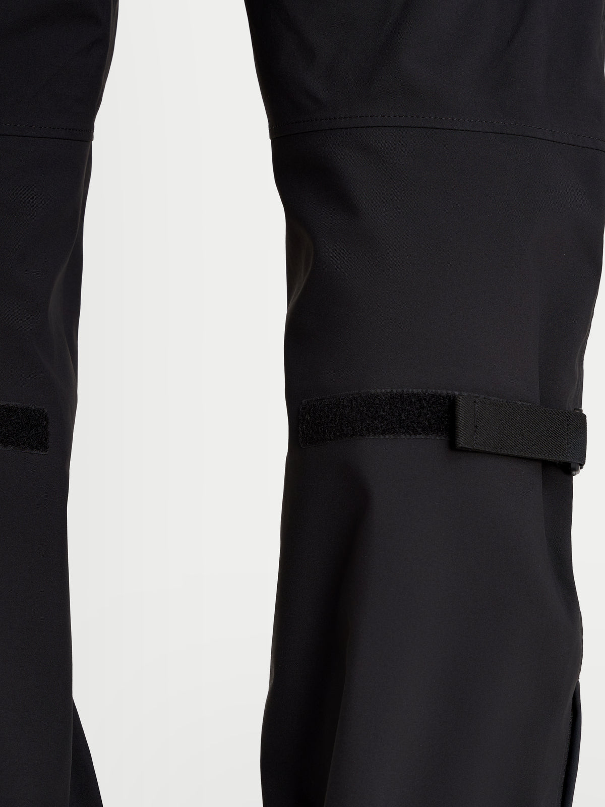 Alpinestars Juggernaut V2 Drystar Pants, men's urban waterproof motorcycle pants in black, close-up view showing lower leg adjusters and technical textile construction