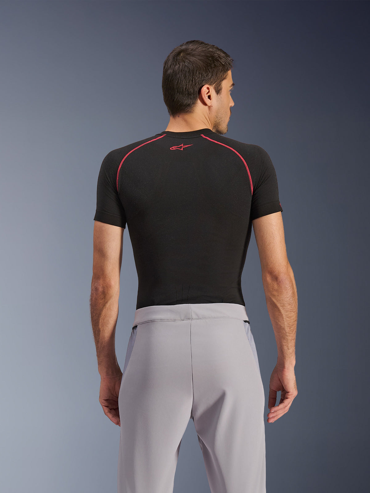 Alpinestars Aeroshell Airflow Pants, Mid Gray, back view, worn with a black short-sleeve base layer with red stitching and logo, featuring lightweight stretch softshell textile and mesh paneling for maximum ventilation, ergonomic sport fit for motorcycle riding