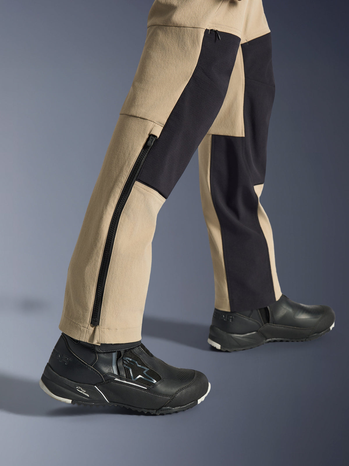 Alpinestars Woman Stella Flex-AST Explorer Pants, Motorcycle Adventure Pants, Sand and Black, close-up view of the lower legs and ankles featuring a long side zipper and black reinforcement panels, worn with black Alpinestars riding shoes.