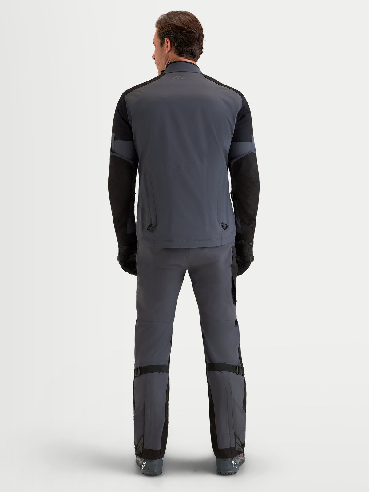 Alpinestars Arenis Gore-Tex Gear Set, men's adventure touring motorcycle jacket and pants in gray and black, rear view on a model wearing waterproof all-terrain riding apparel