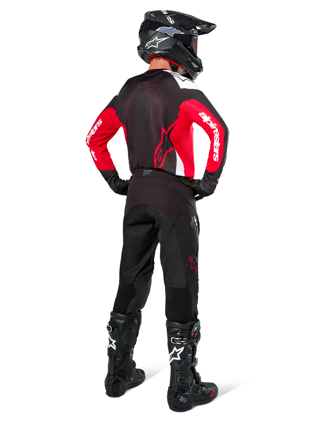 Motocross rider from behind wearing Alpinestars Pro-Dura Pants in Black Magnet White, paired with a red and black jersey and black boots, coordinated off-road gear set for enduro riding
