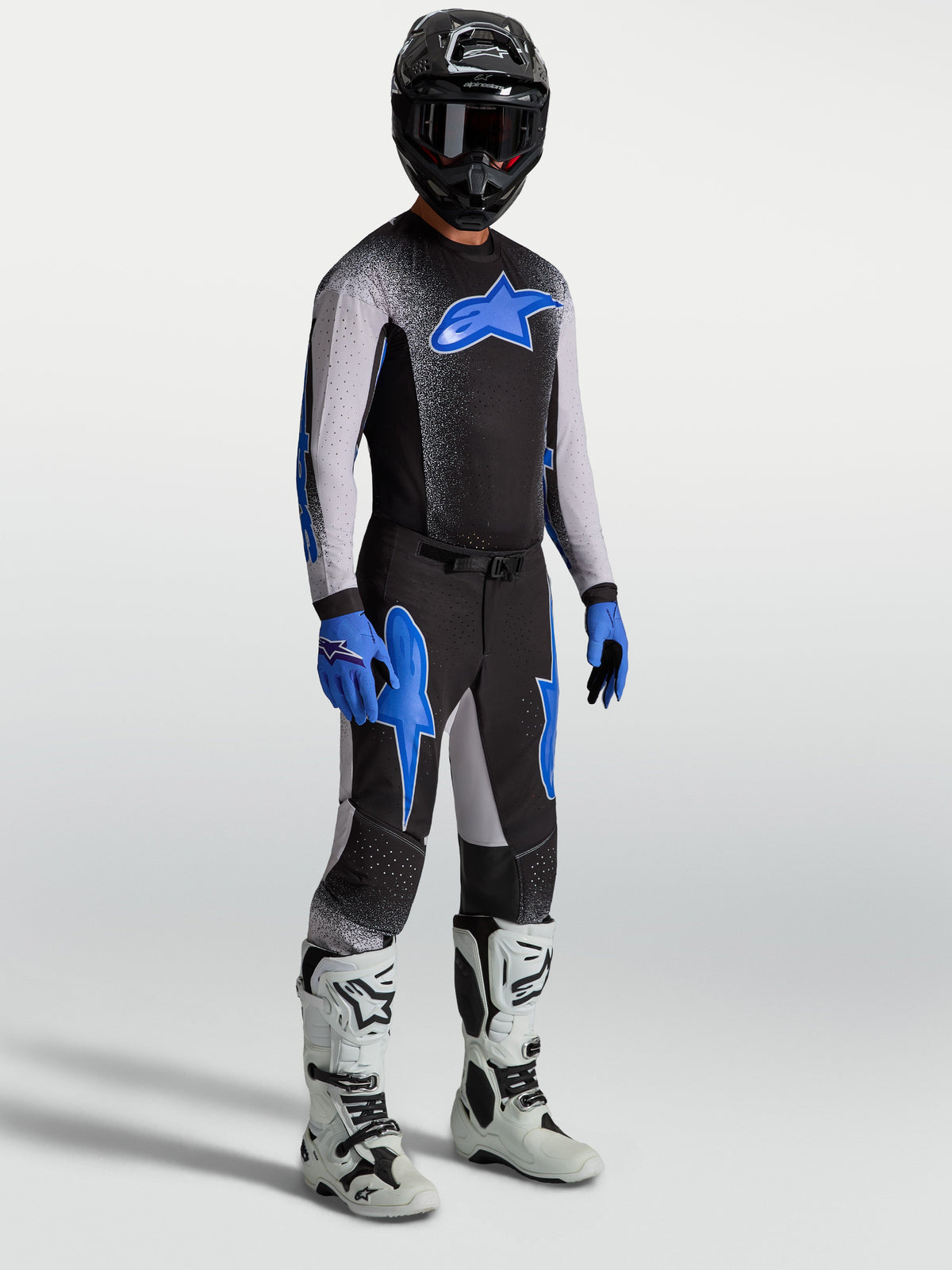 Alpinestars Supertech Hiten AFD Pants, black and blue motocross gear set on model with matching jersey and white boots.