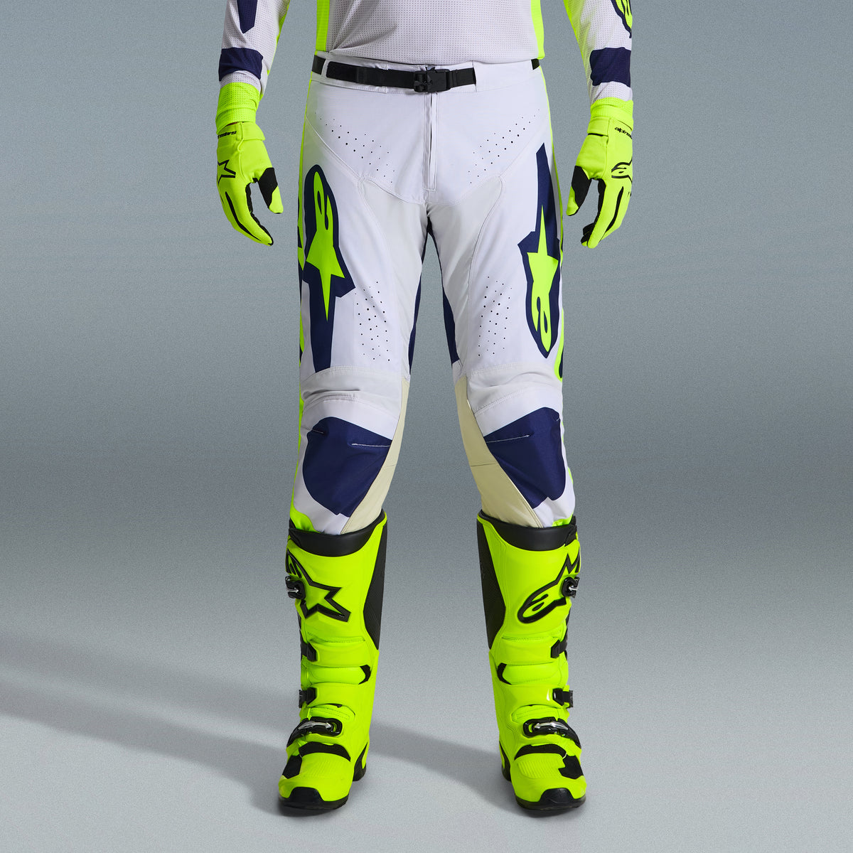 Alpinestars 2026 Racer Air Riway Gear Set, Motocross Pants in White and Navy Blue with Neon Yellow accents, paired with matching neon yellow gloves and boots, featuring ergonomic design and ventilated panels for off-road racing.