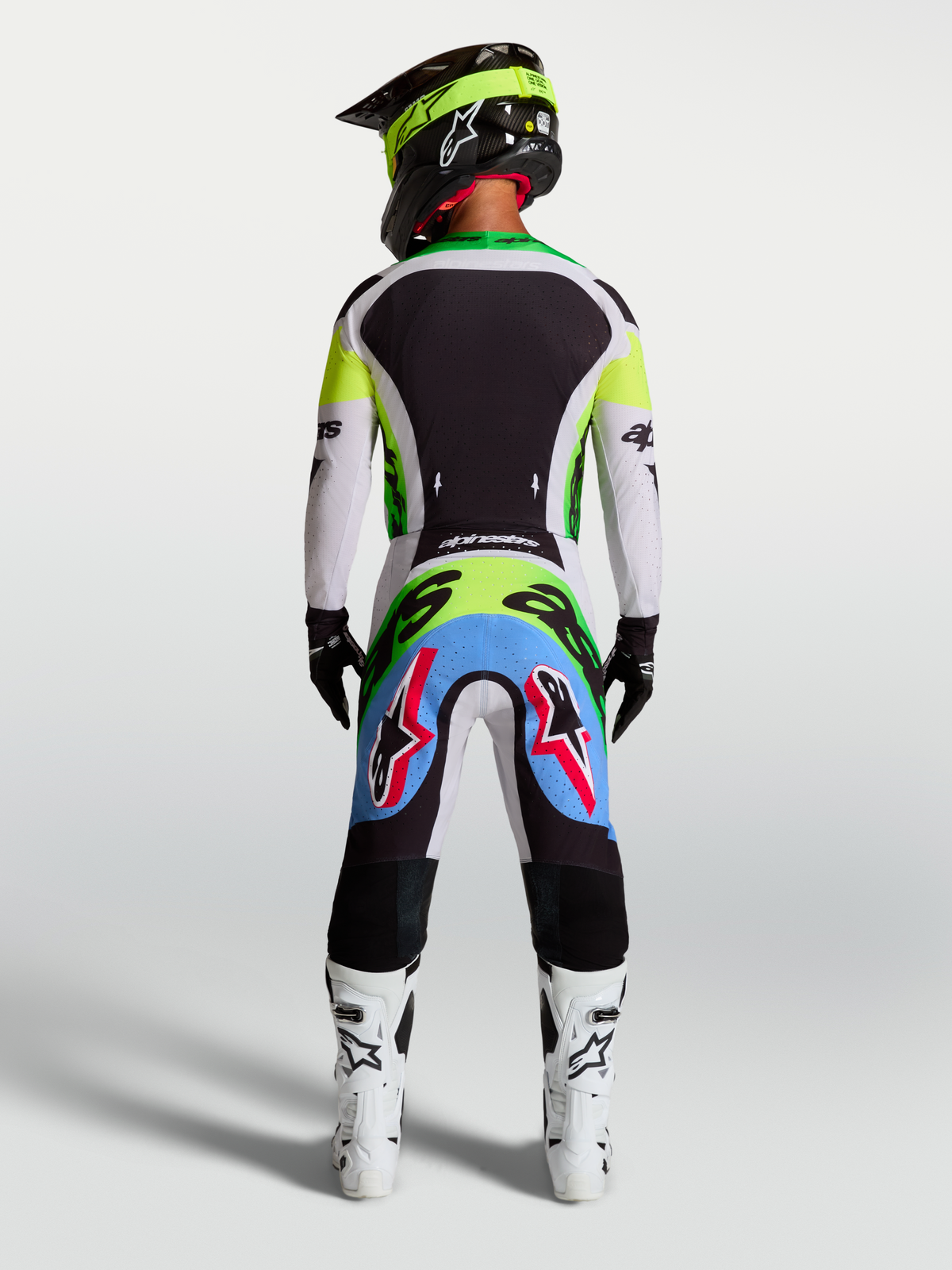 Alpinestars Supertech Dyna Pants, motocross gear in Light Lilac and Green Fluo, rear view on a rider wearing a full race kit.