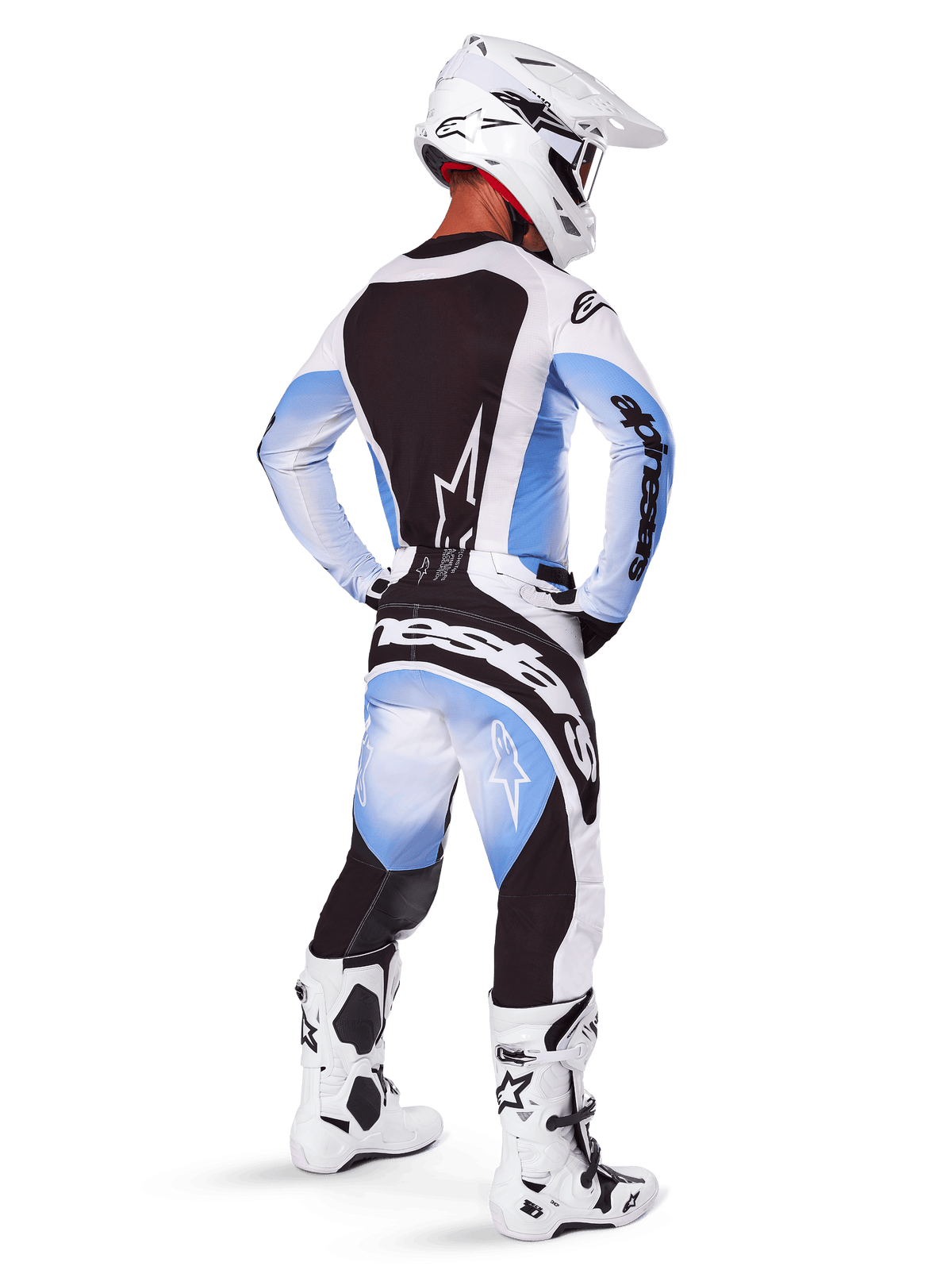 Motocross rider seen from behind wearing Alpinestars 2025 Techstar Melt Pants and jersey, Black Blue and White gradient design, white helmet, white and black boots, full off-road racing kit.