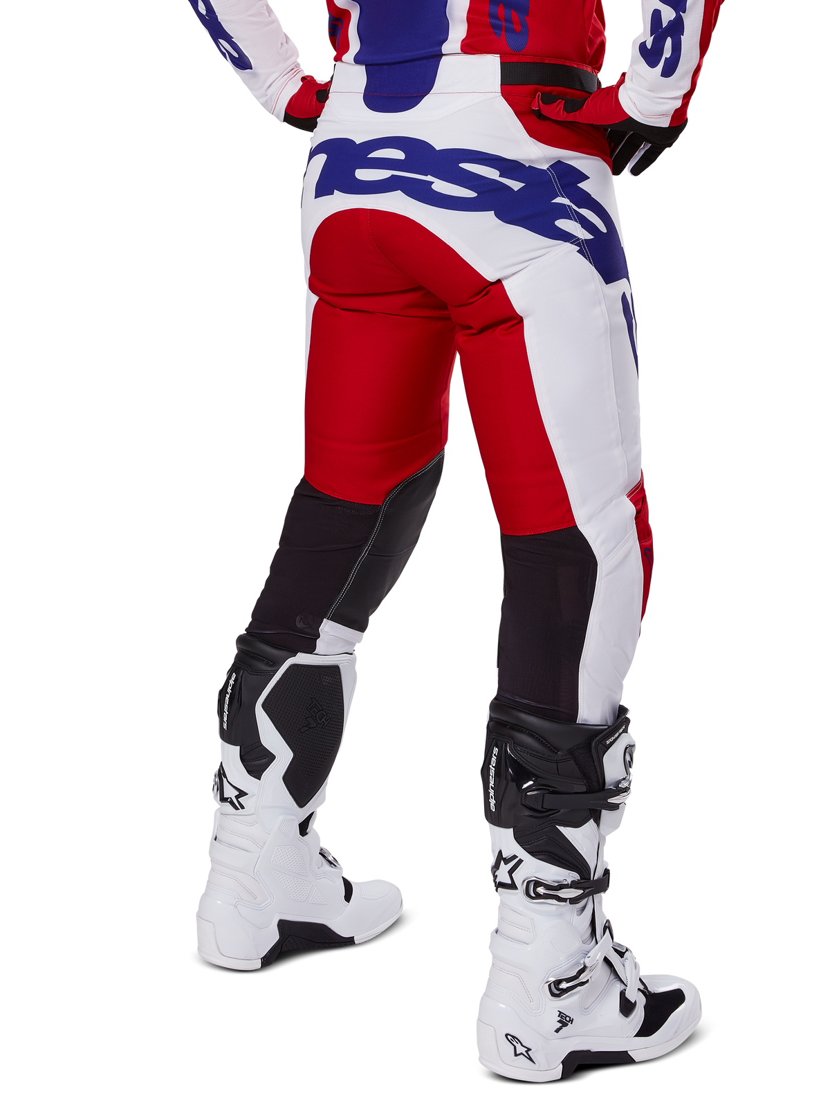 Alpinestars 2025 Racer Veil Pants, Motocross Pants, Bright Red and White with Blue branding, rear view showing black stretch ventilation panels on the back of the legs, paired with white motocross boots.