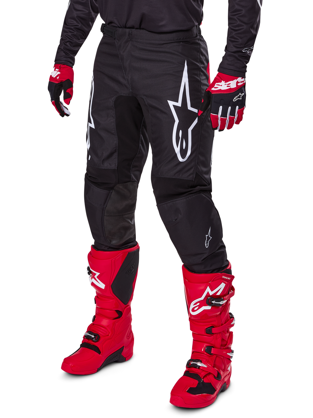 Alpinestars 2025 Fluid Haul Pants, Motocross Pants, Black, featuring a large white Alpinestars logo, worn with bright red boots and red and black gloves, durable 600D polyfabric construction with ergonomic cut for off-road racing