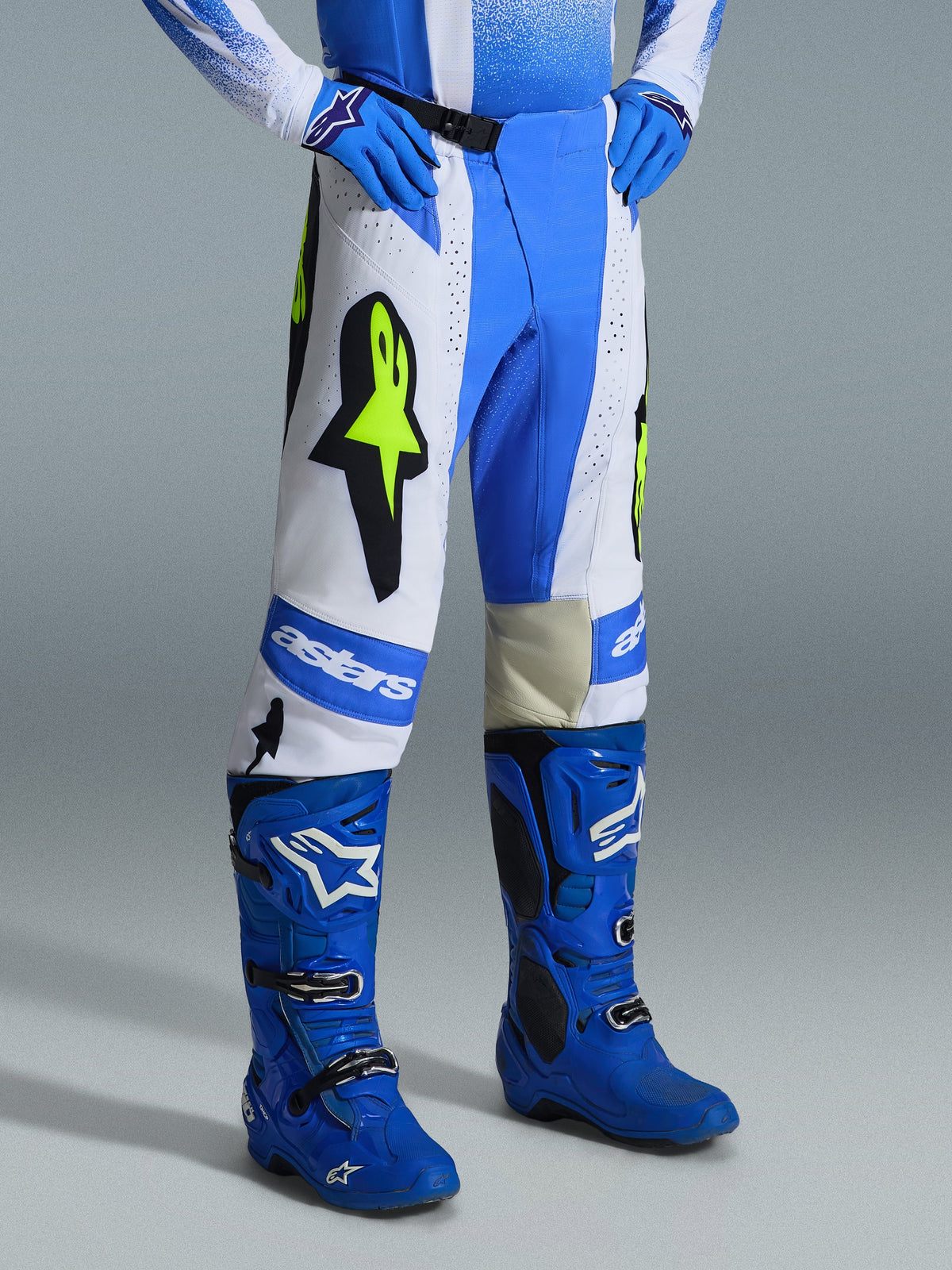 Alpinestars 2026 Techstar Knif Pants, Motocross Pants, Ucla Blue, White, and Black with Yellow Fluo, worn with matching blue boots and gloves, featuring bold Alpinestars branding and Astar logos, high-performance gear for off-road racing.