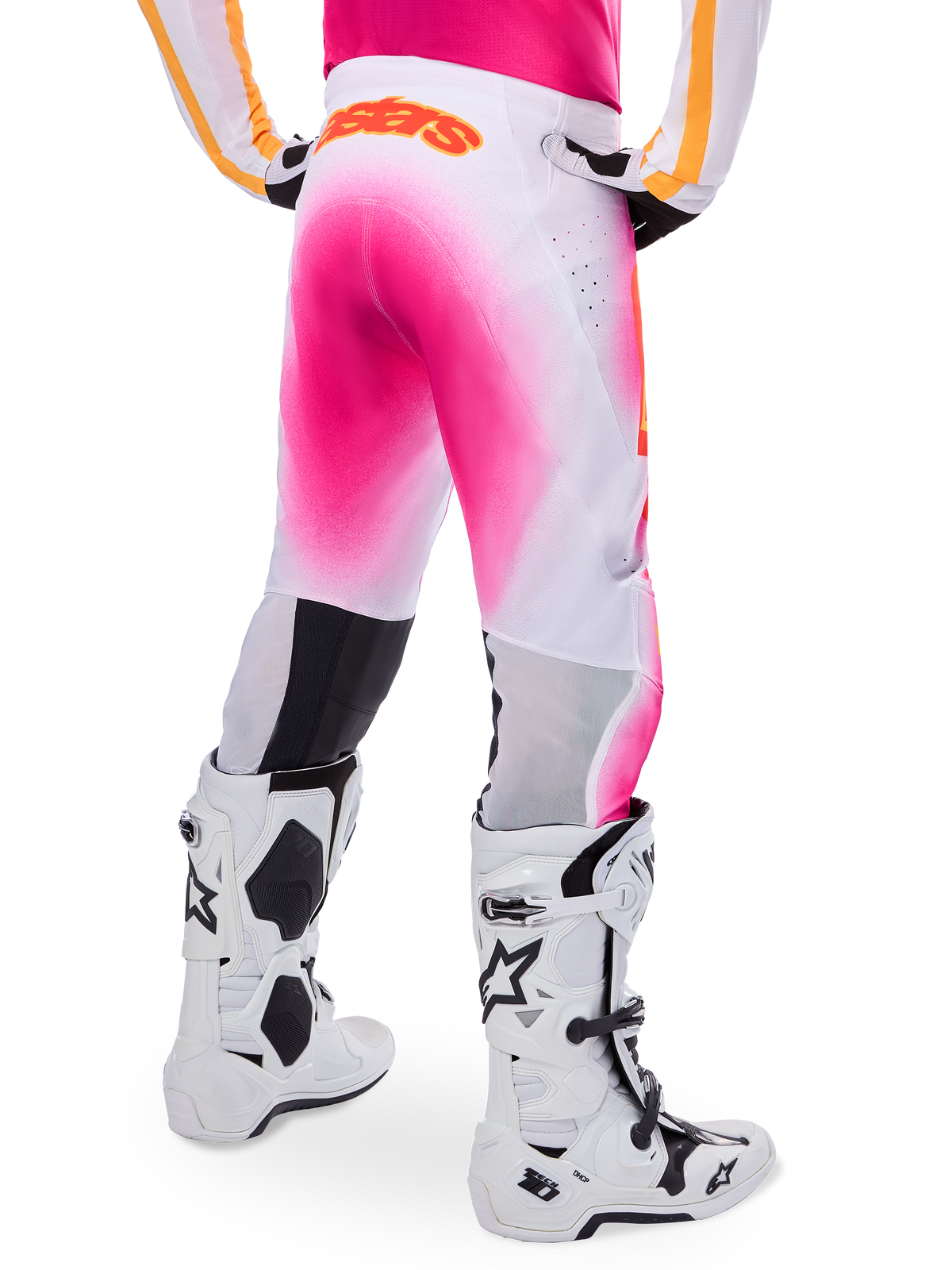 Alpinestars Supertech AFD MIG Limited Edition Motocross Pants, Pink and White, rear view featuring a vibrant pink gradient spray effect, orange logo on the back waist, paired with white and black Tech 10 boots, professional off-road racing apparel